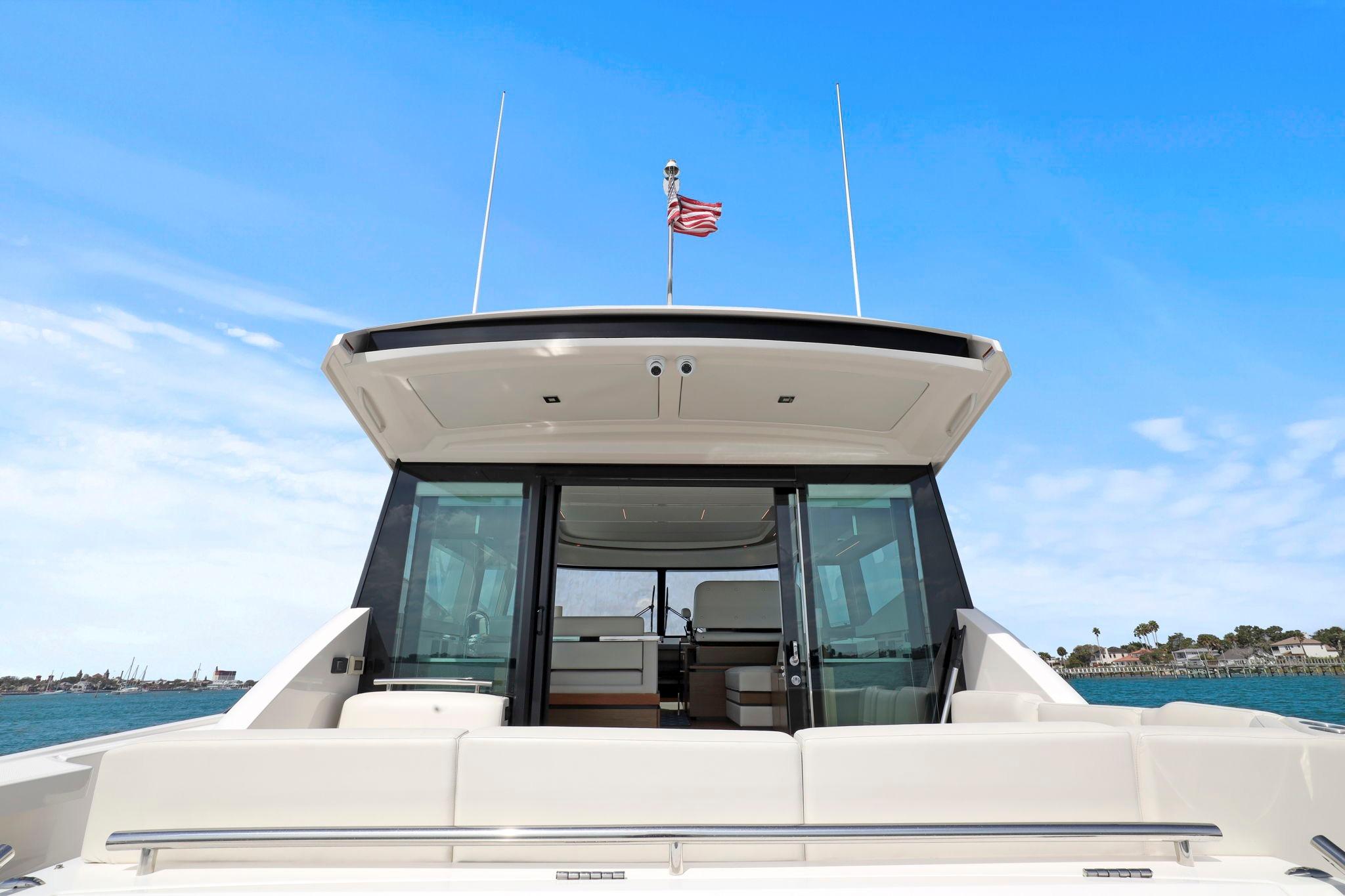 2023 Tiara Yachts C49 Coupe, rear view, open sea, clear sky, luxury design.