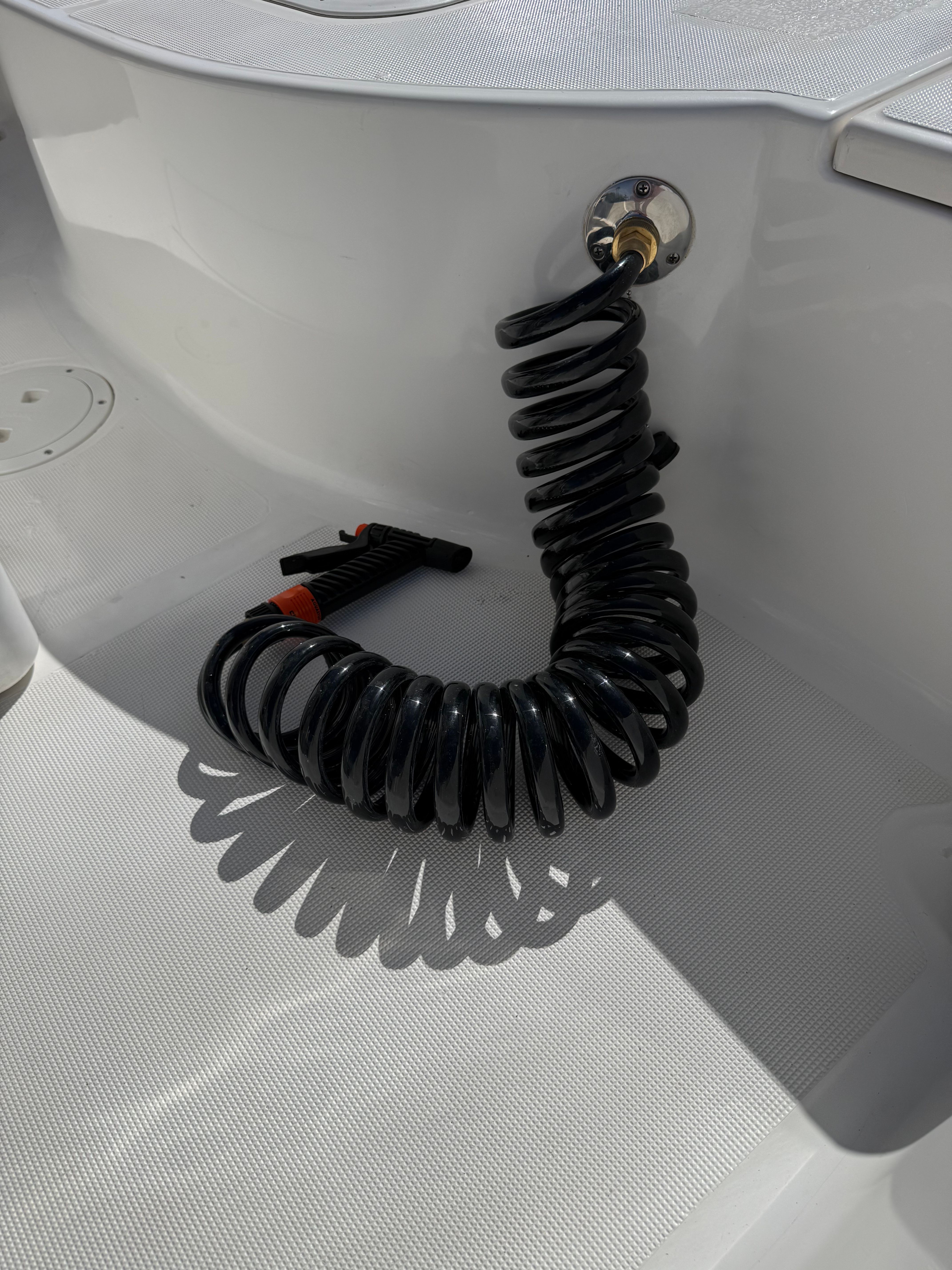 Black coiled hose on a 1998 Robalo 2100 Bay Hunter boat.