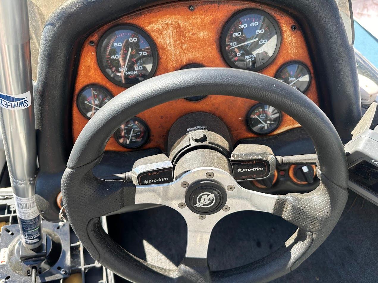 Dashboard of a 1999 Fisher 21 FX DC boat with steering wheel and gauges.