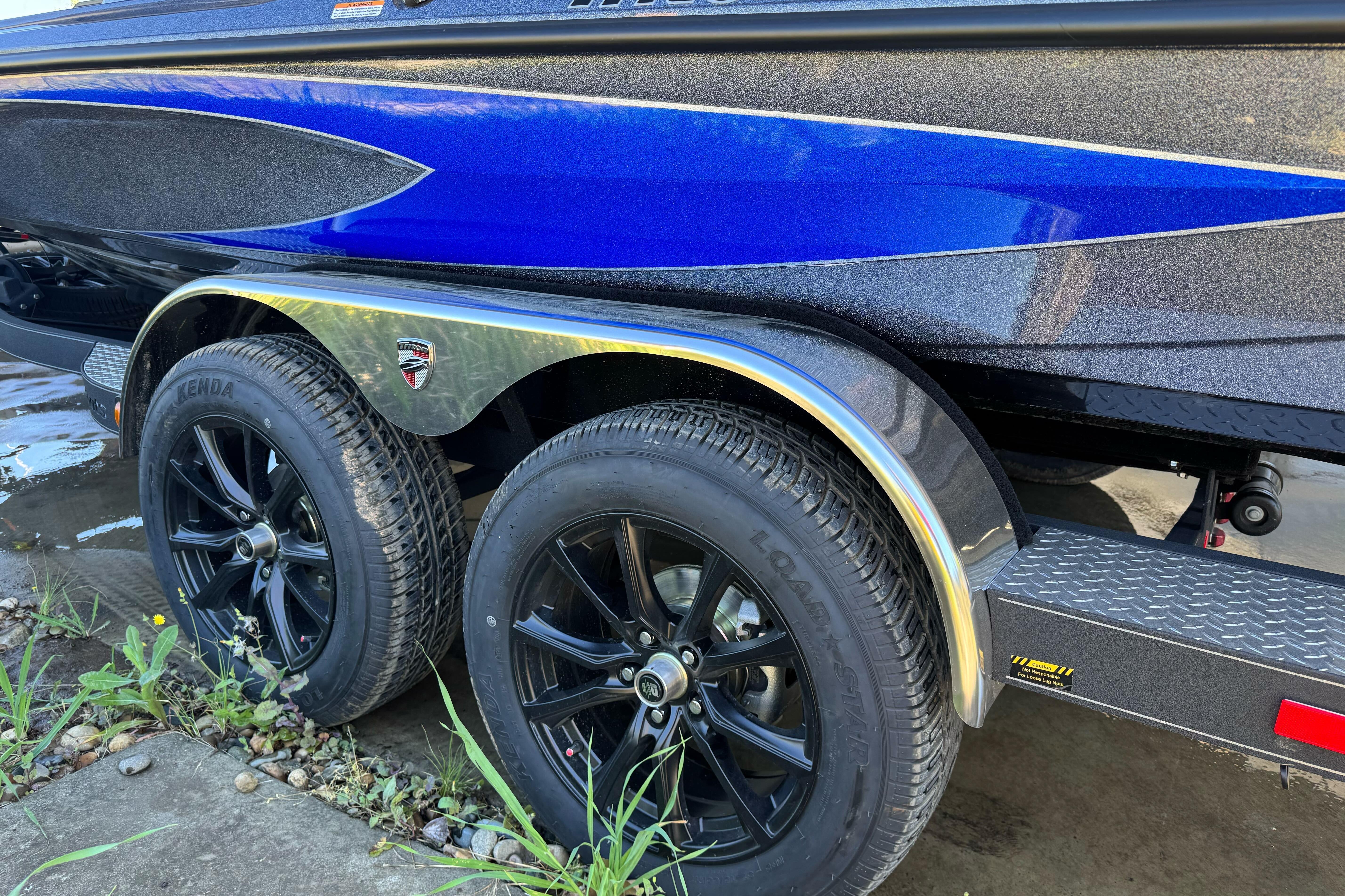 2026 Triton 21XP Patriot boat trailer with dual black wheels and blue accents.