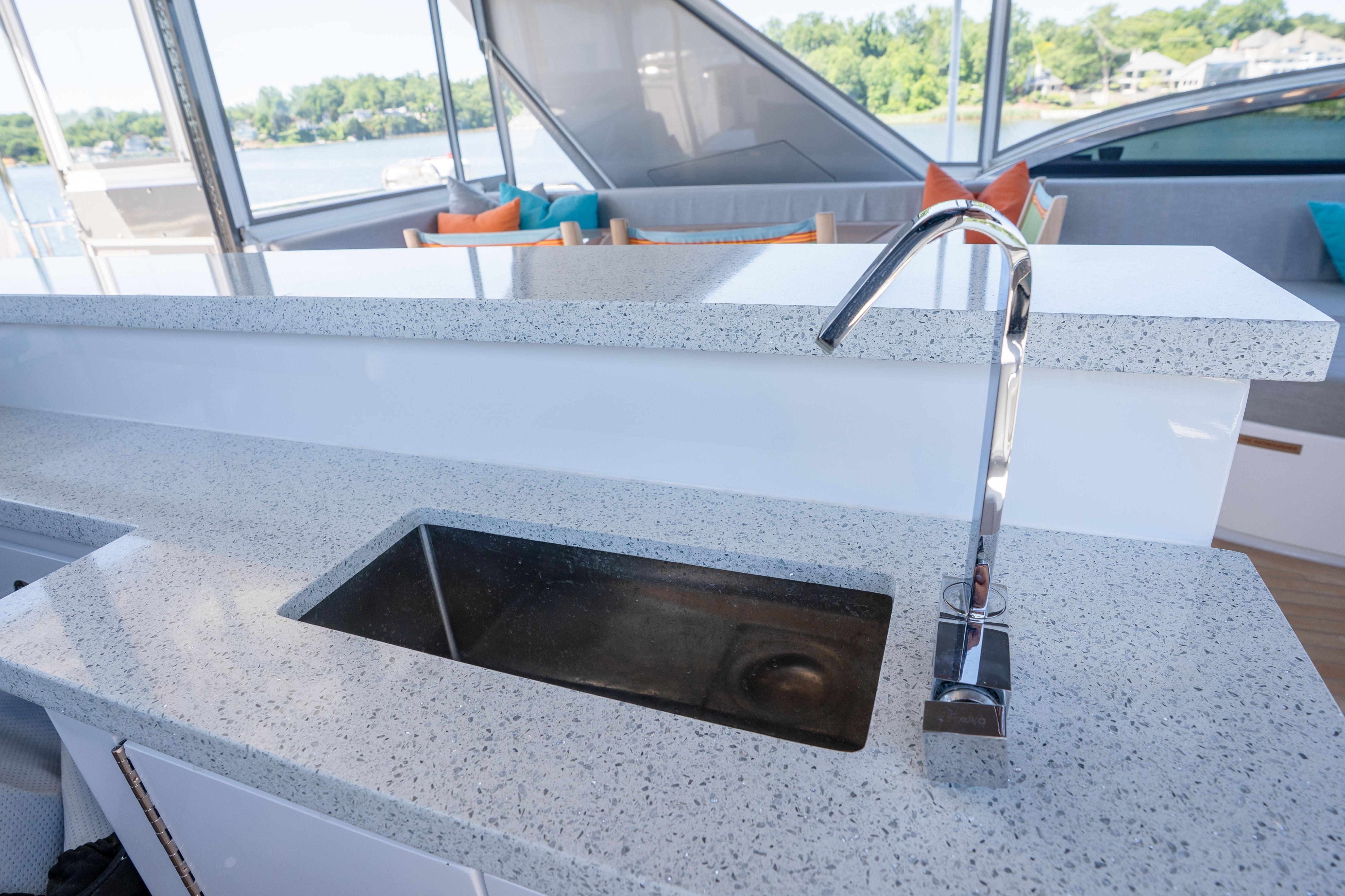 Luxurious 2021 Hatteras M75 Panacera yacht kitchen with sleek countertop and modern faucet.