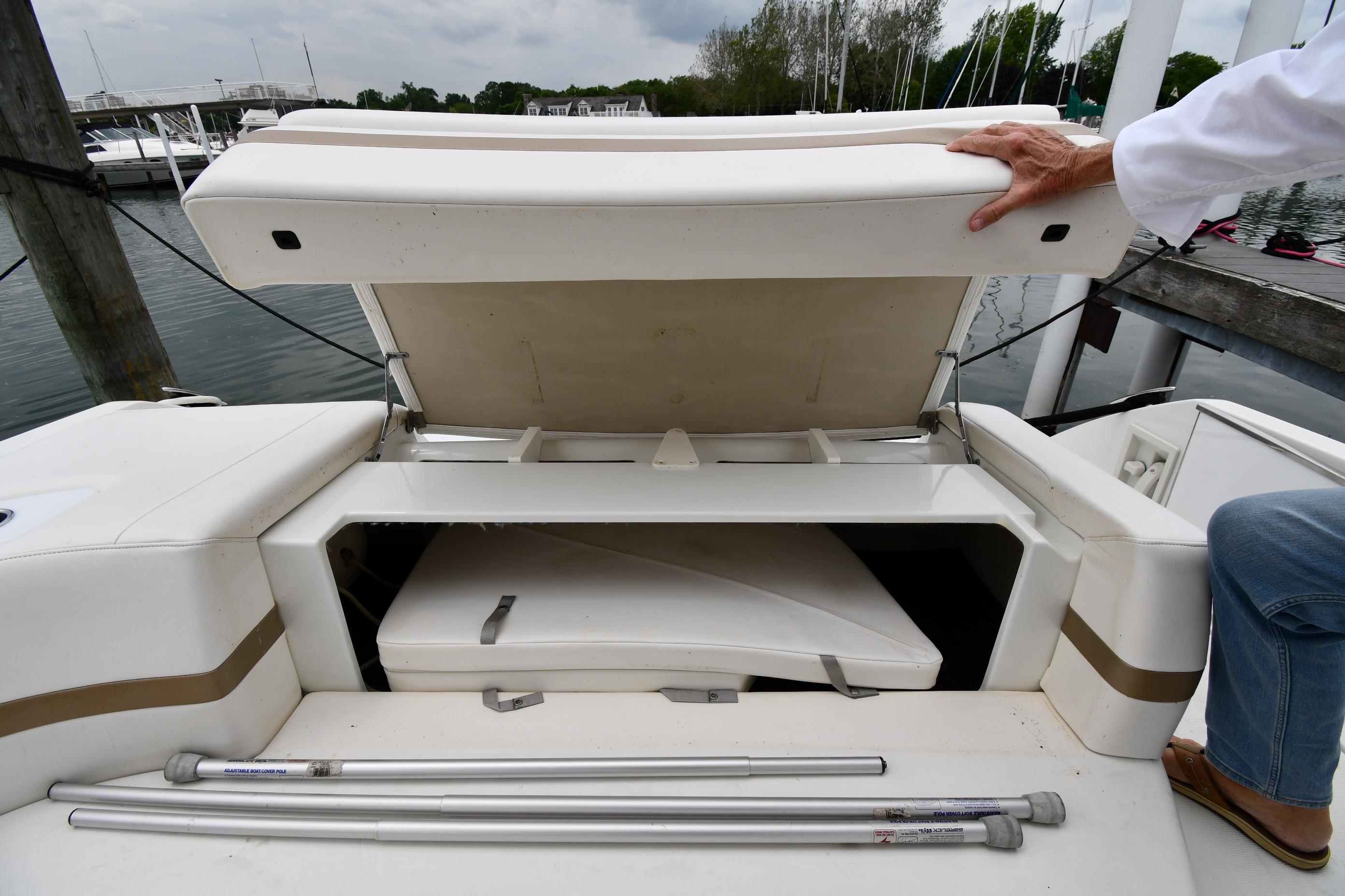Open storage compartment on a 2004 Formula 330 Sun Sport boat at a marina.