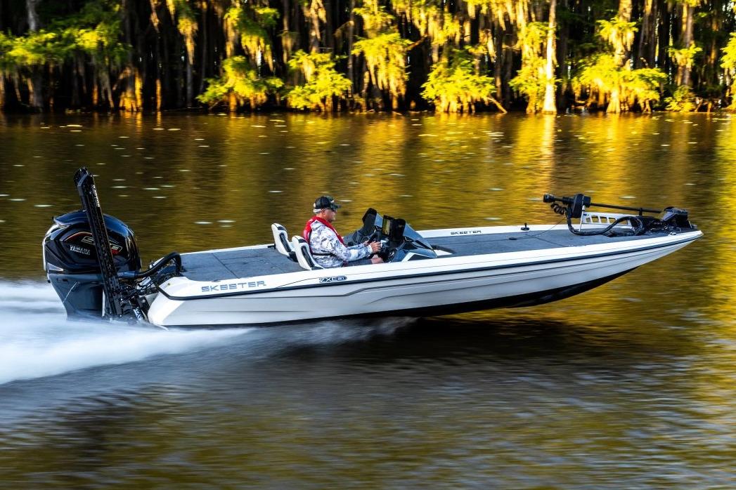Manufacturer Provided Image: 2026 Skeeter ZXE21 boat speeding on a scenic lake with lush greenery.