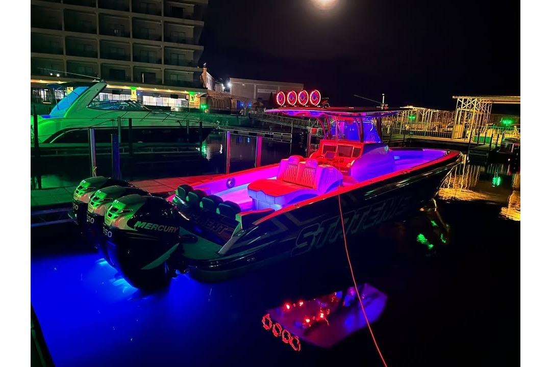 2017 Statement 380 Open boat illuminated with vibrant neon lights at night.