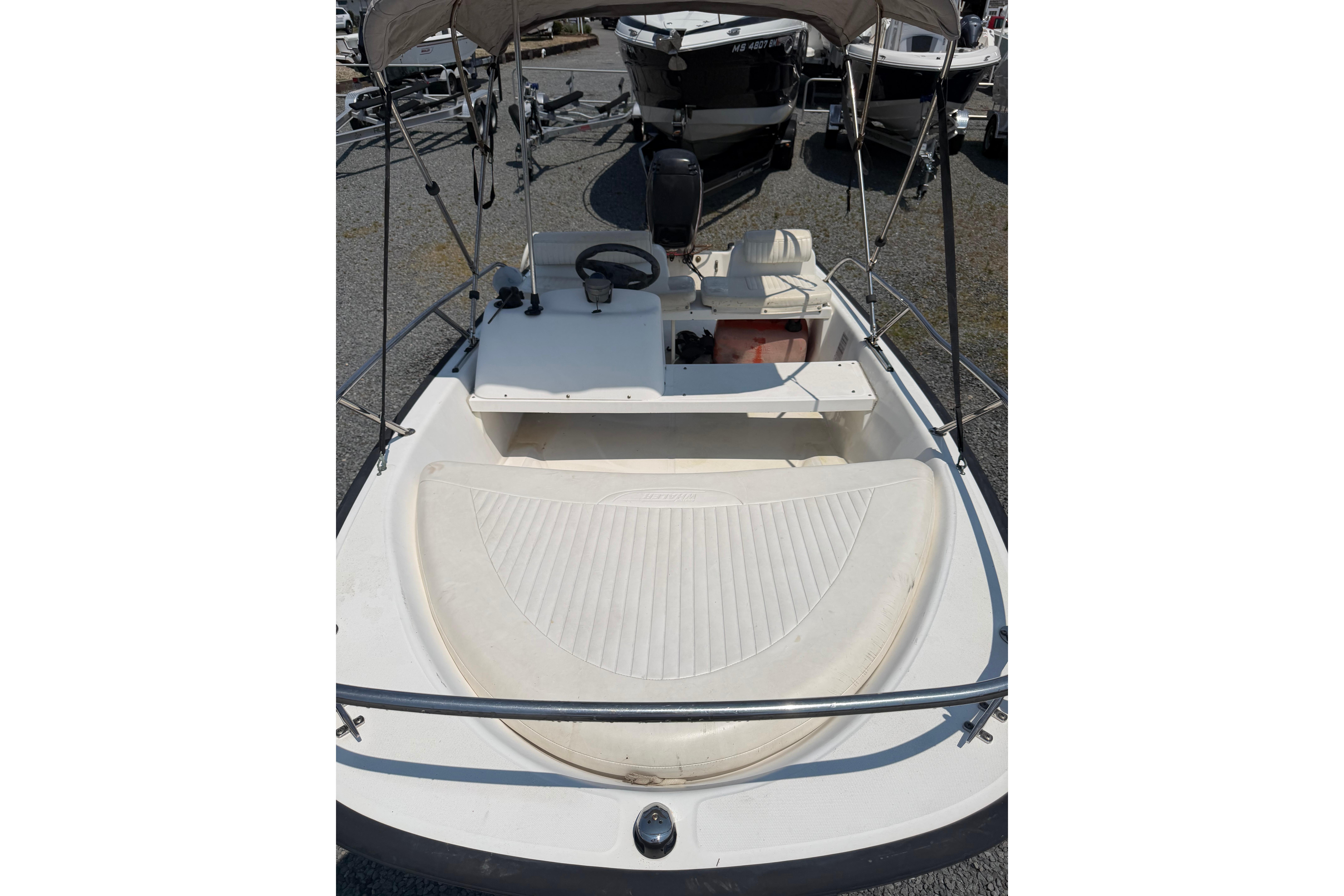 2003 Boston Whaler 130 Super Sport boat interior with steering wheel and seating area.