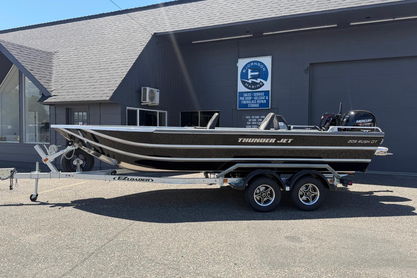 2026 Thunder Jet 209 Rush OT boat on trailer outside marine service building.