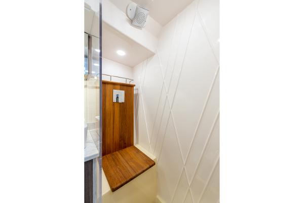 Manufacturer Provided Image: 2026 Regal 38 SAV shower with wooden bench and modern white walls.