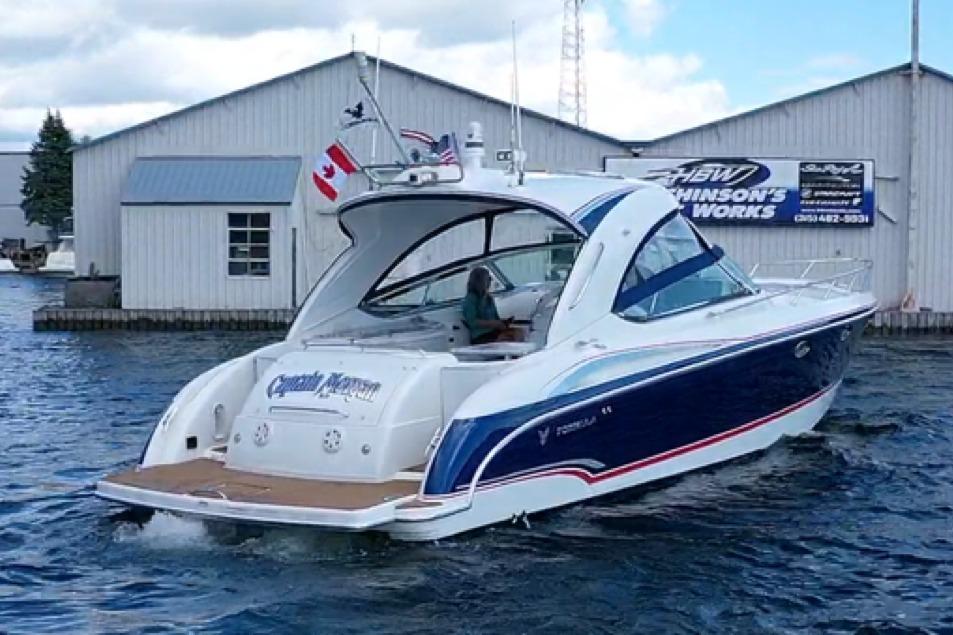2008 Formula 400 Super Sport boat on water near marina buildings.