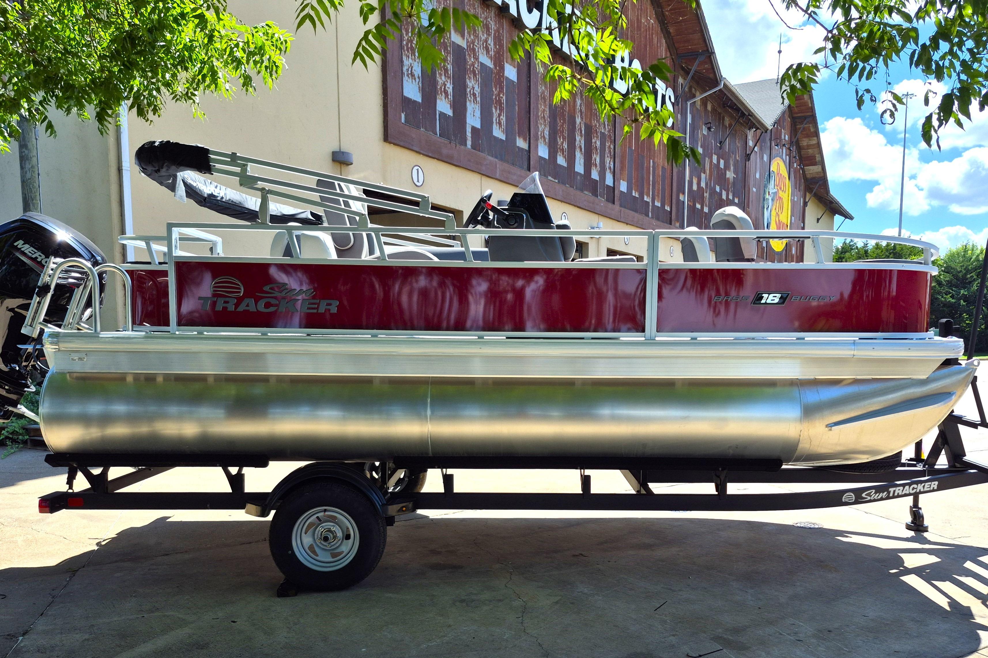 2026 Sun Tracker Bass Buggy 18 DLX pontoon boat on trailer, outdoors.