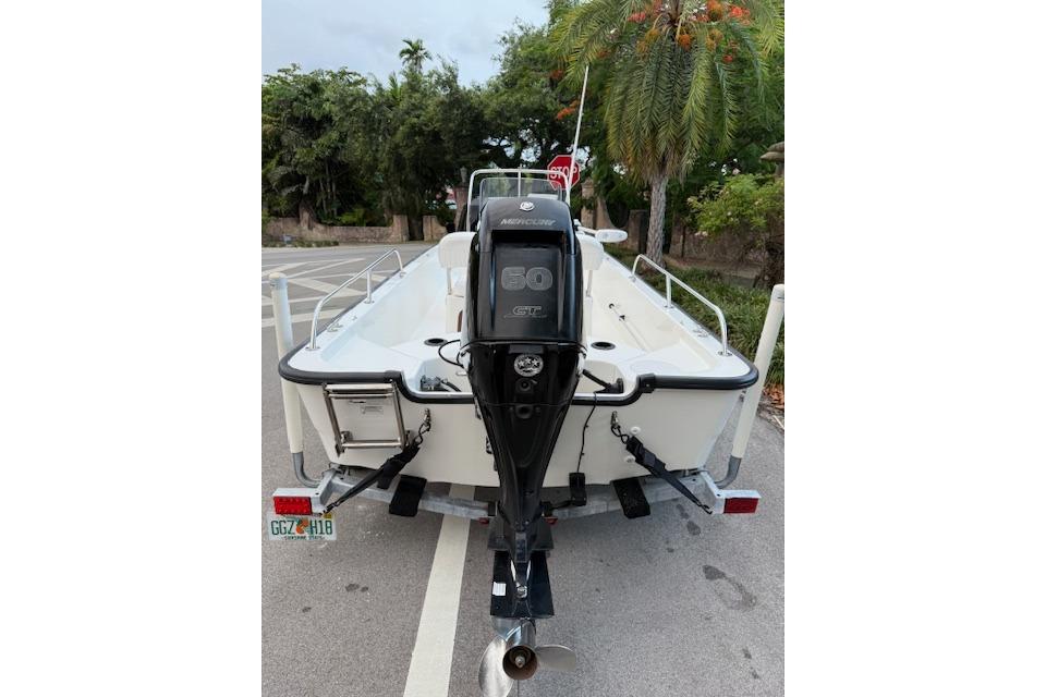 2016 Boston Whaler 150 Montauk boat with Mercury 60 HP engine, parked on trailer.