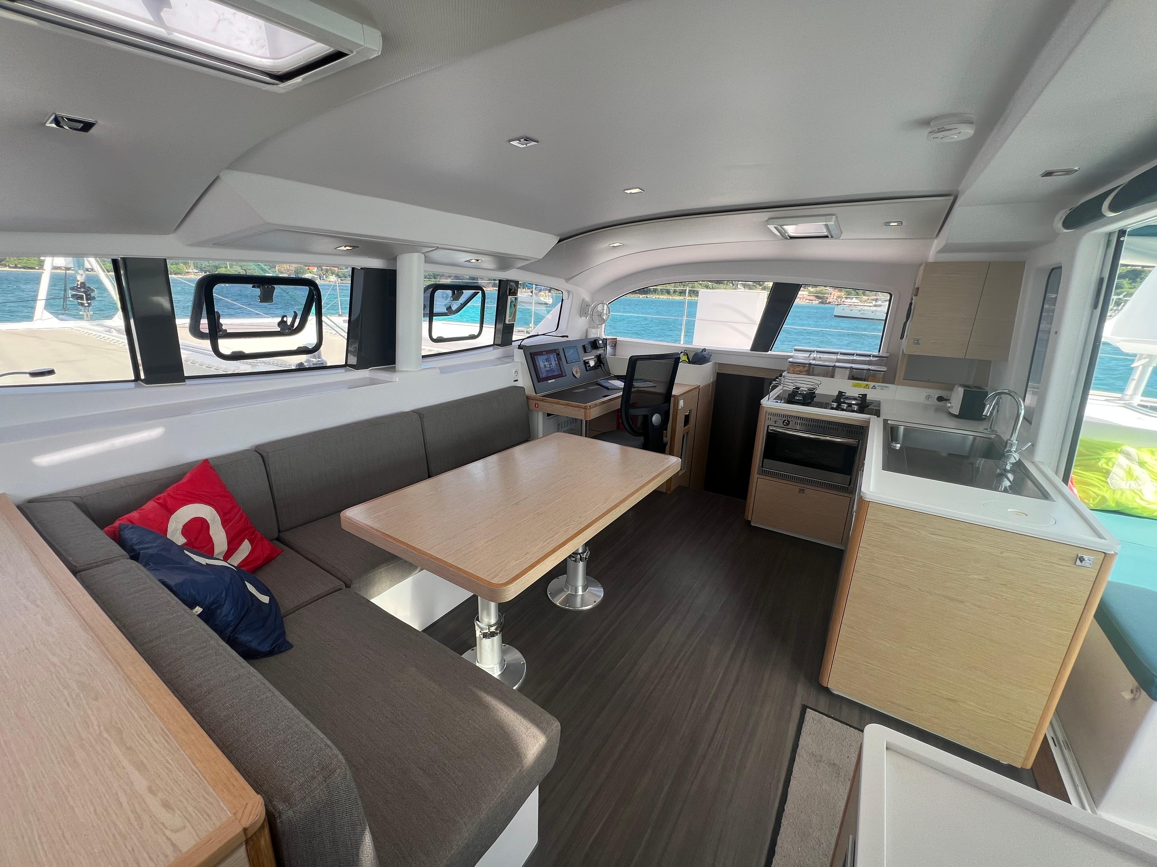 Modern interior of 2024 Outremer 45 catamaran with dining area and kitchen.