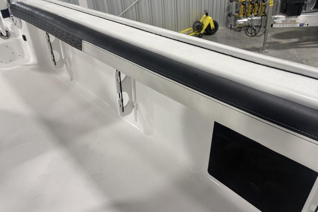2026 Tidewater 2300 Carolina Bay boat interior with padded side rail and rod holders.