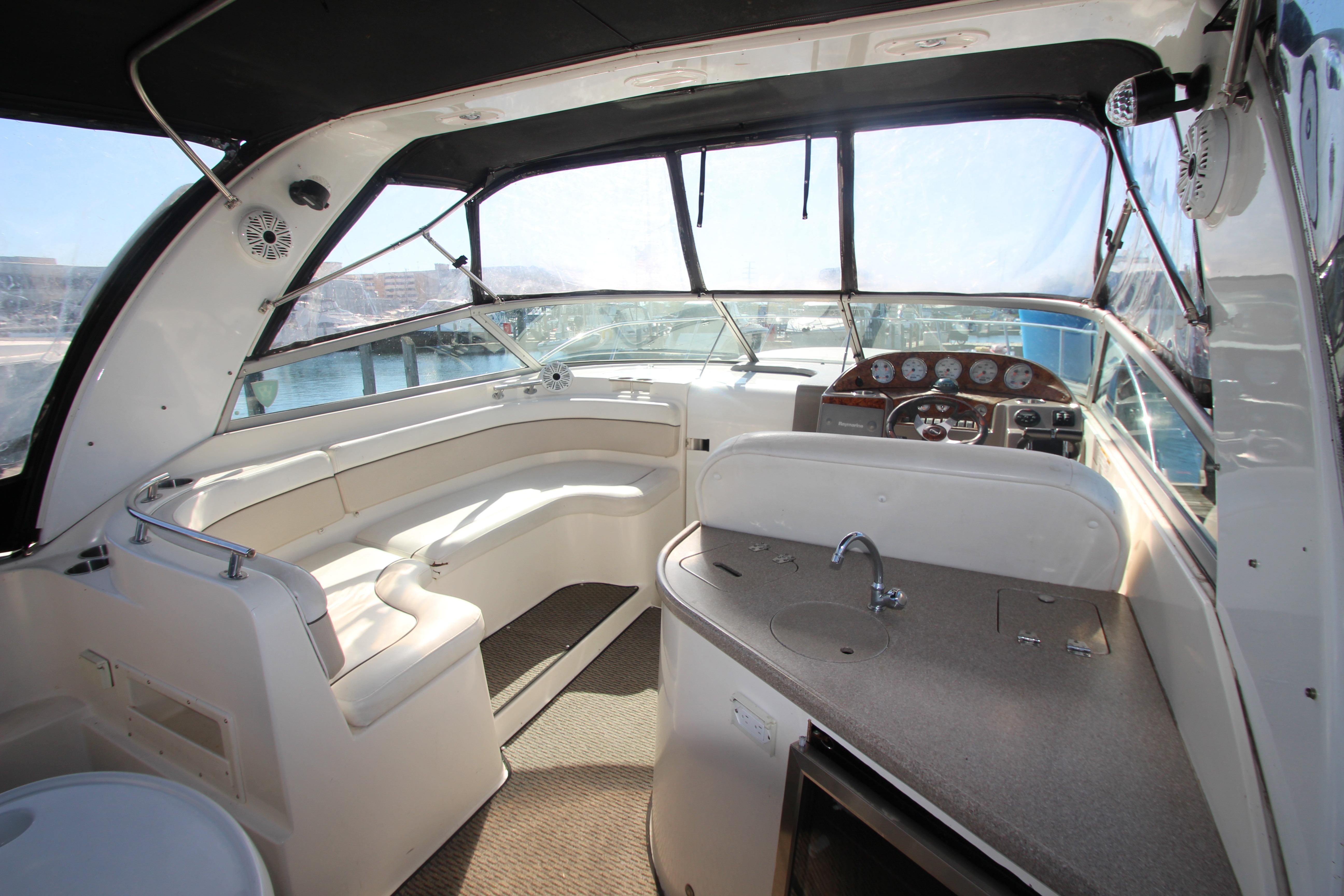 2006 Rinker 320 Express Cruiser interior with helm, seating, and kitchenette.