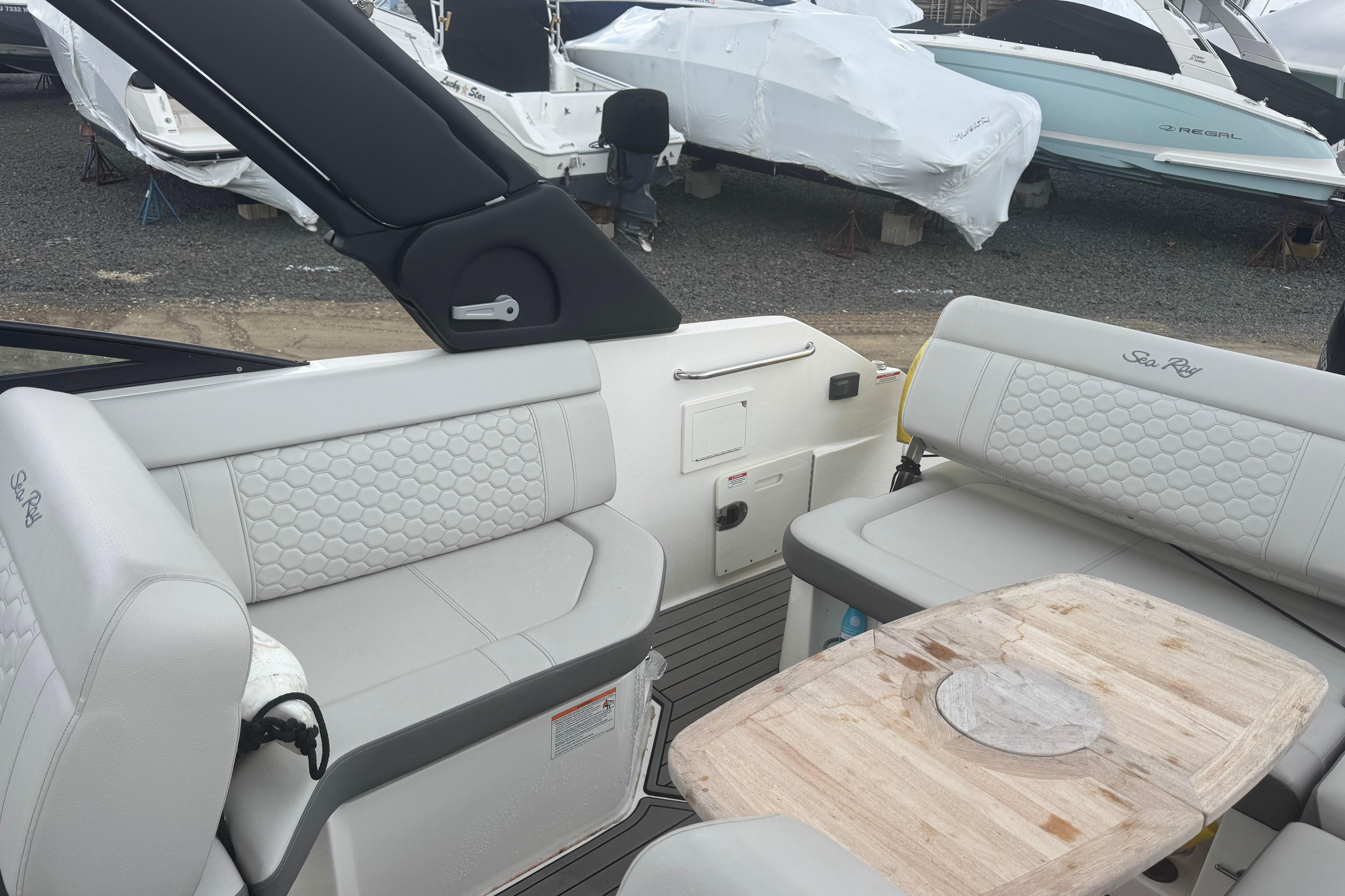 2024 Sea Ray SDX 250 Outboard interior with luxurious seating and wooden table.