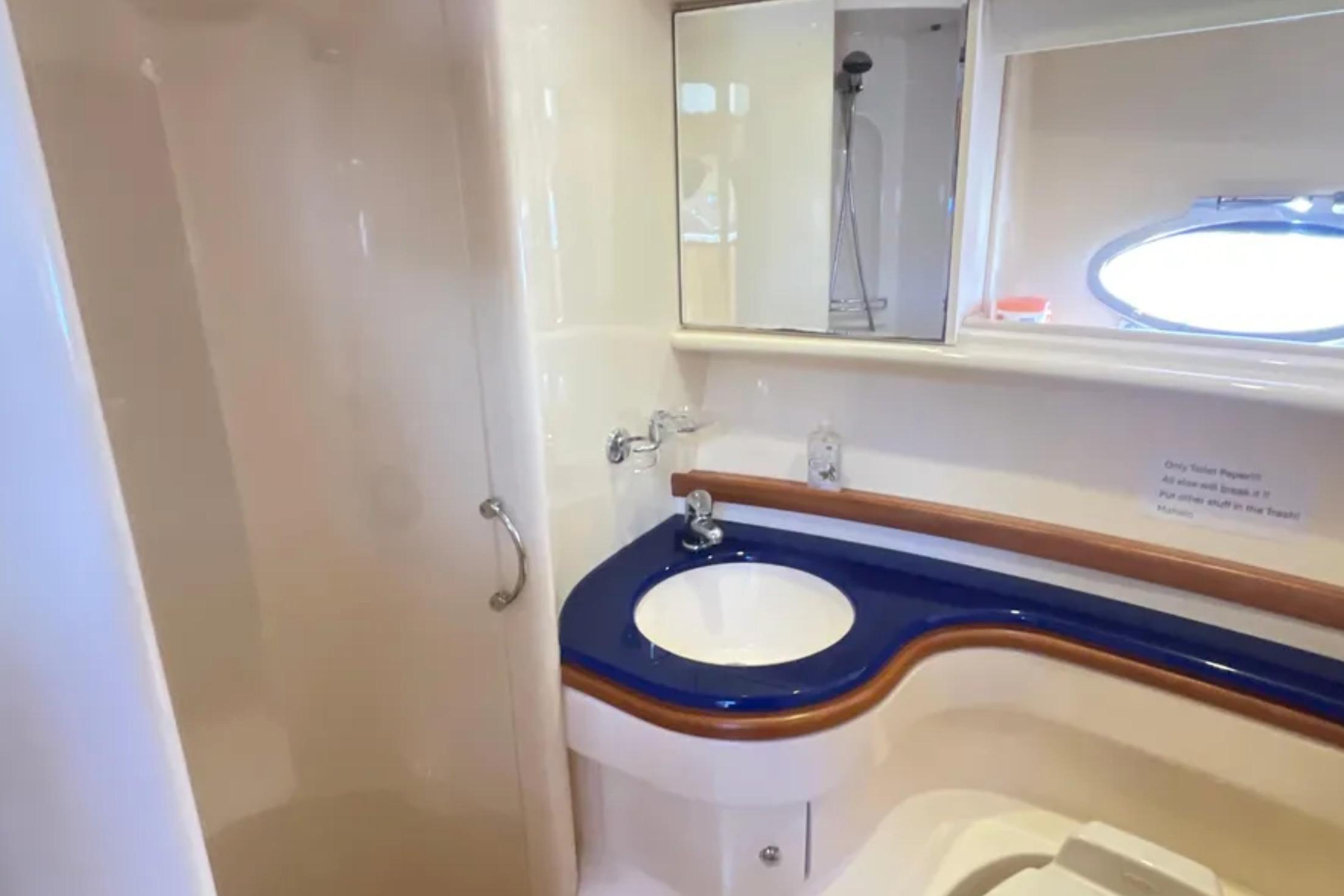 Bathroom interior of 2004 Azimut 46 yacht, featuring a sleek sink and shower area.