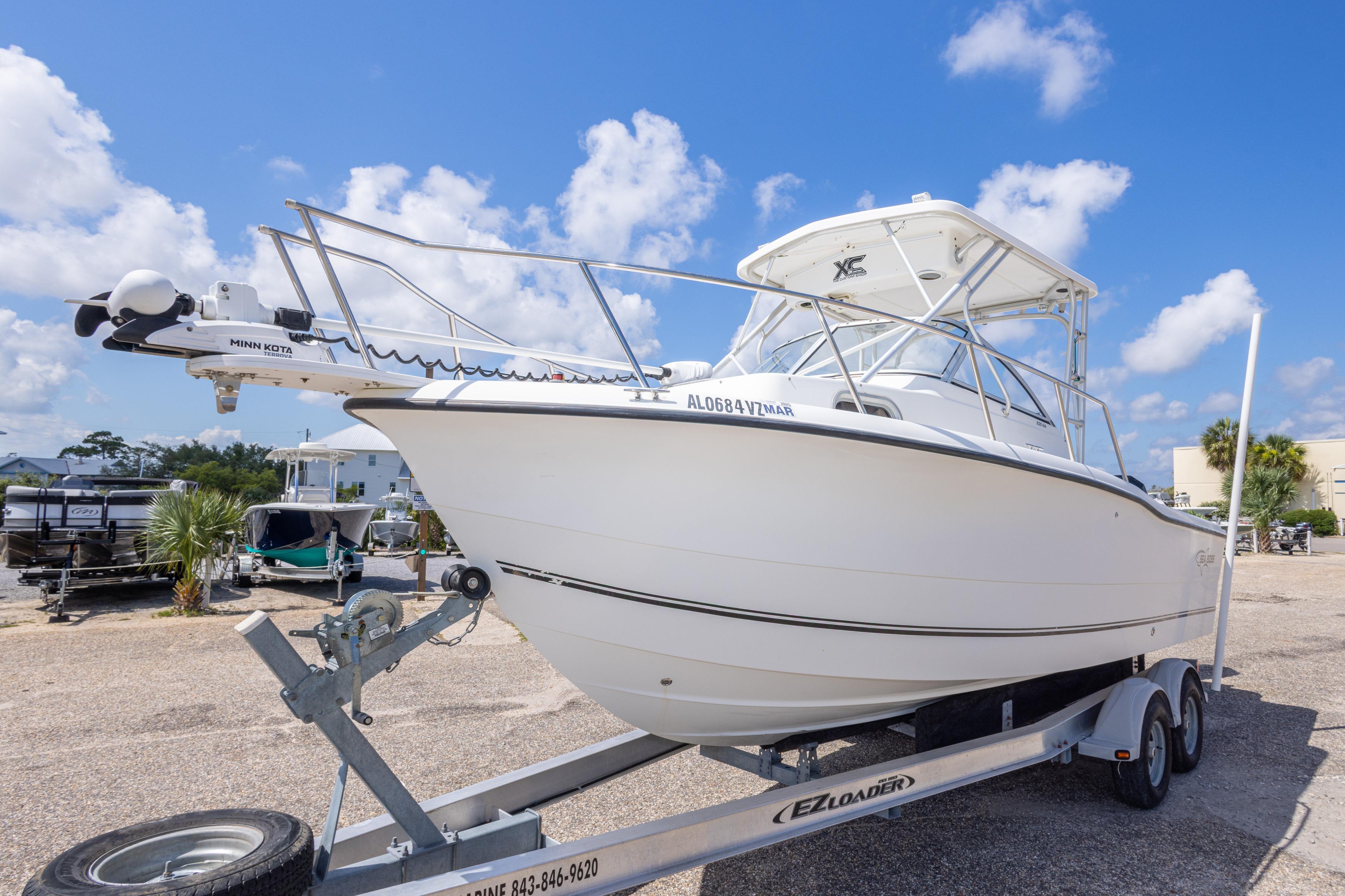 2007 Sea Boss 235 Walkaround boat on trailer under clear blue sky.
