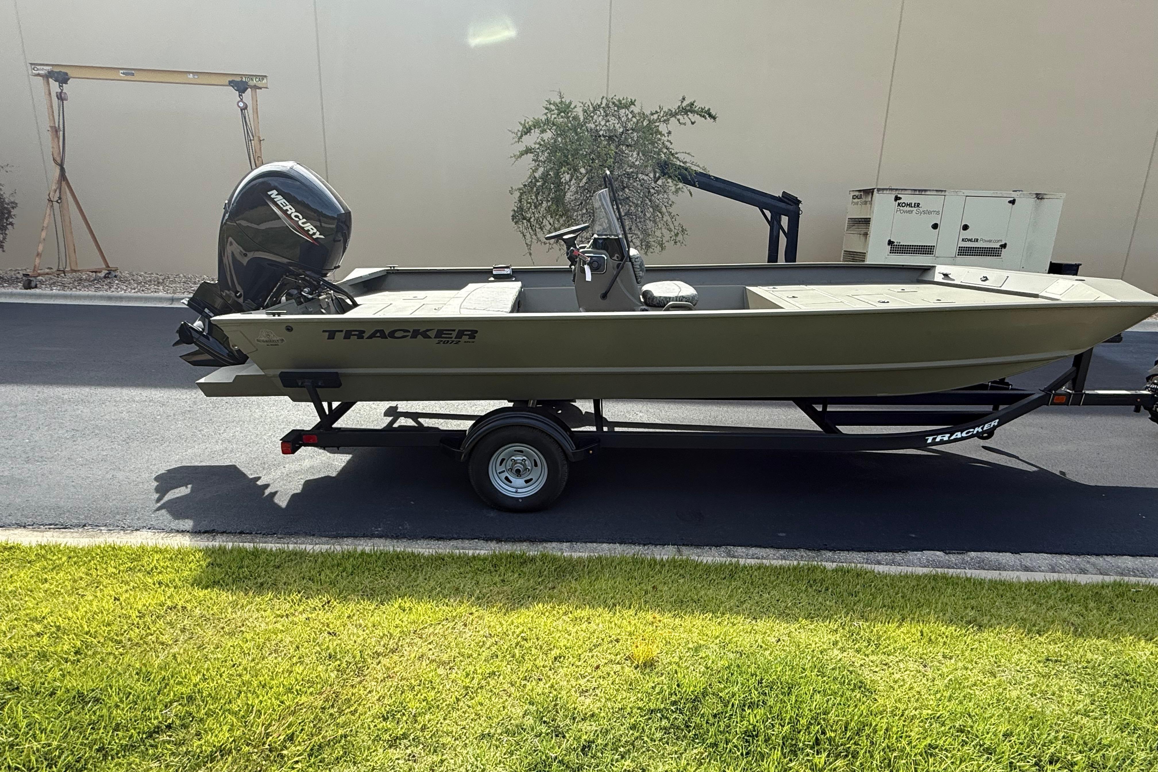 2026 Tracker Grizzly 2072 CC boat on trailer, parked outdoors.