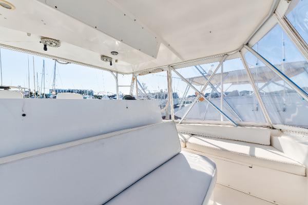 Interior view of 1999 Viking 47 Convertible yacht with white seating and windows.