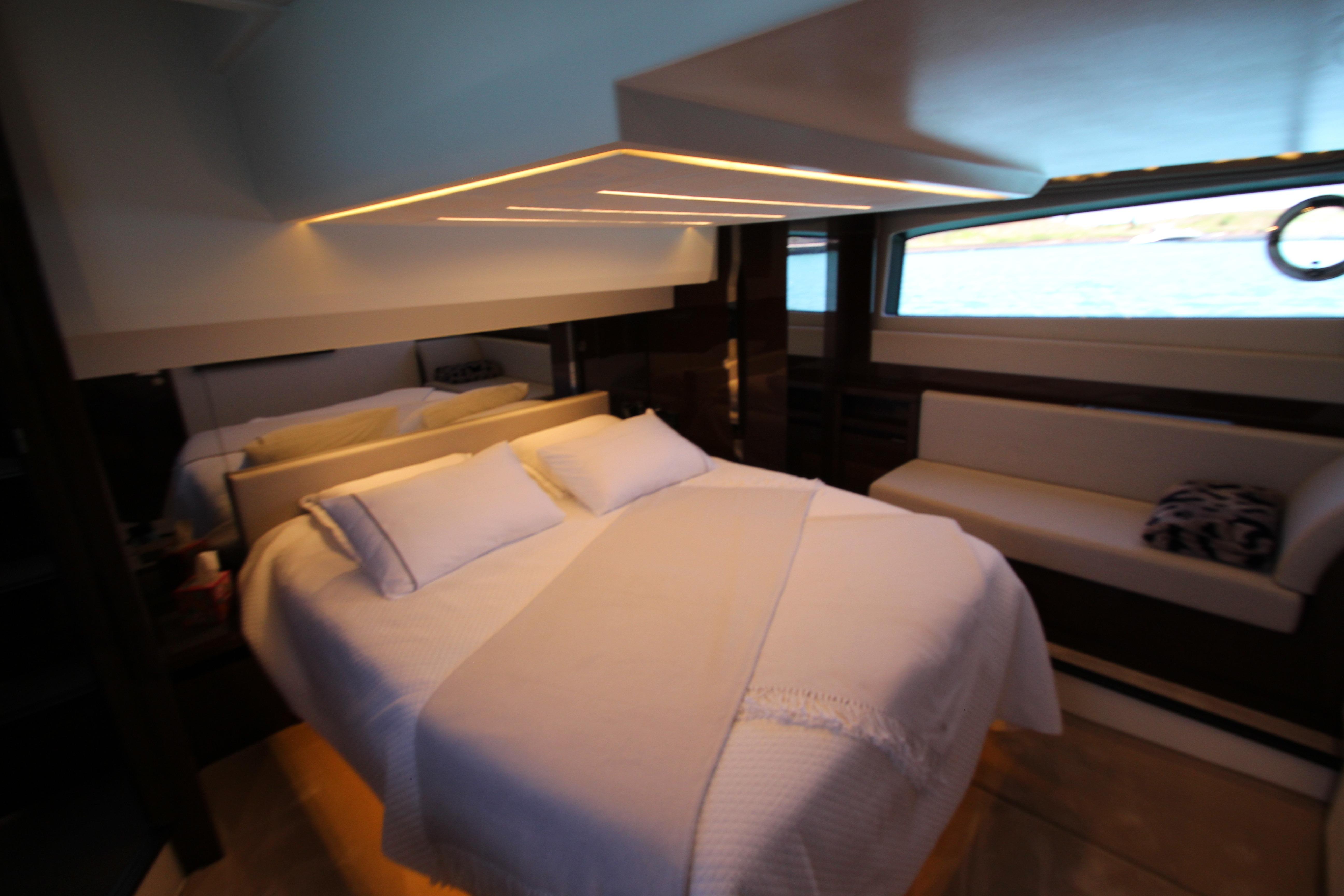 Luxurious bedroom interior of 2022 Prestige 520 yacht with modern lighting and elegant furnishings.