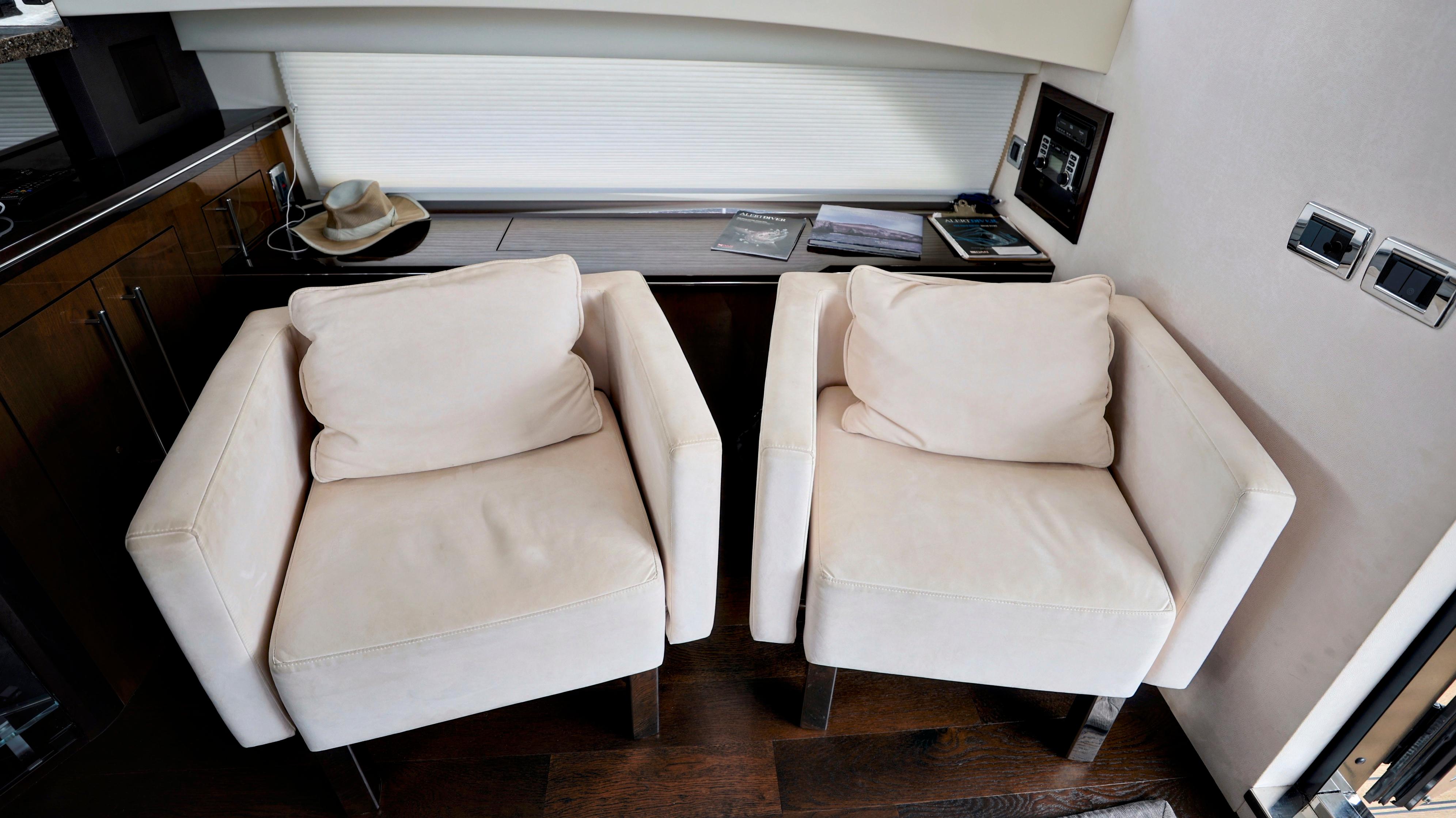 Luxurious interior of 2013 Marquis 500 Sport Bridge with two white armchairs.