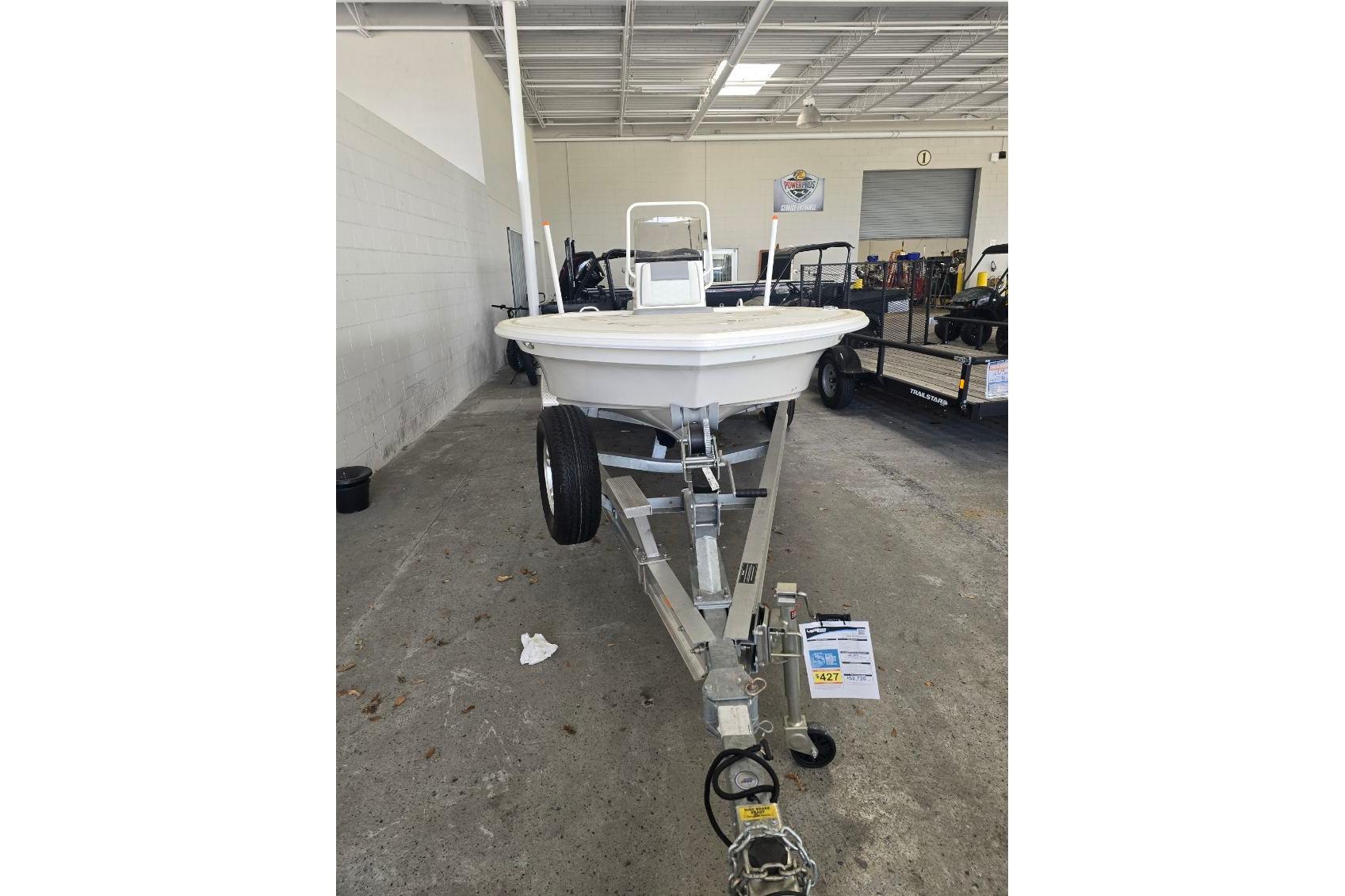 2026 Mako 18 Pro Skiff boat on trailer in indoor showroom.