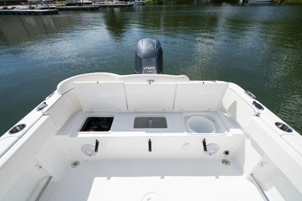 2024 Sea Hunt Ultra 234 boat stern with storage compartments and outboard motor.