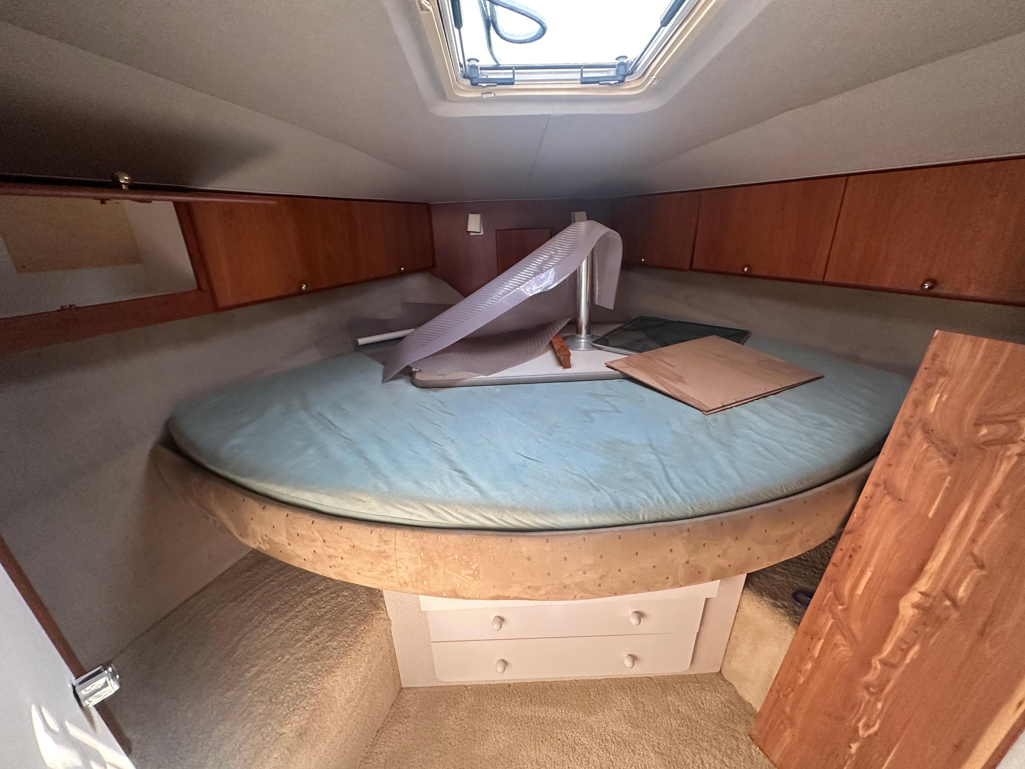 1994 Silverton 34 Aft Cabin Motor Yacht interior with round bed and wooden cabinets.