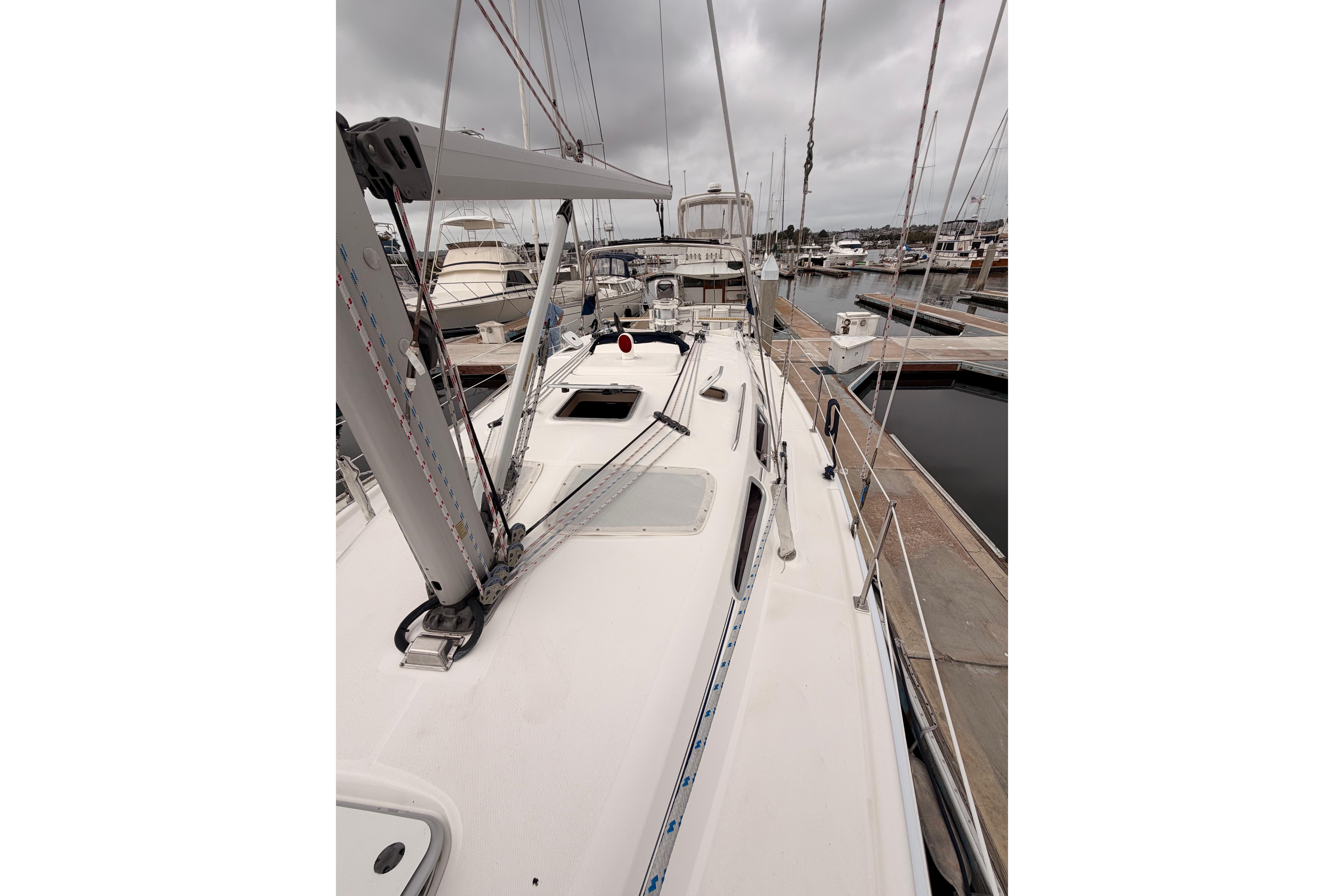 2009 Hunter 38 sailboat docked at marina under cloudy skies.