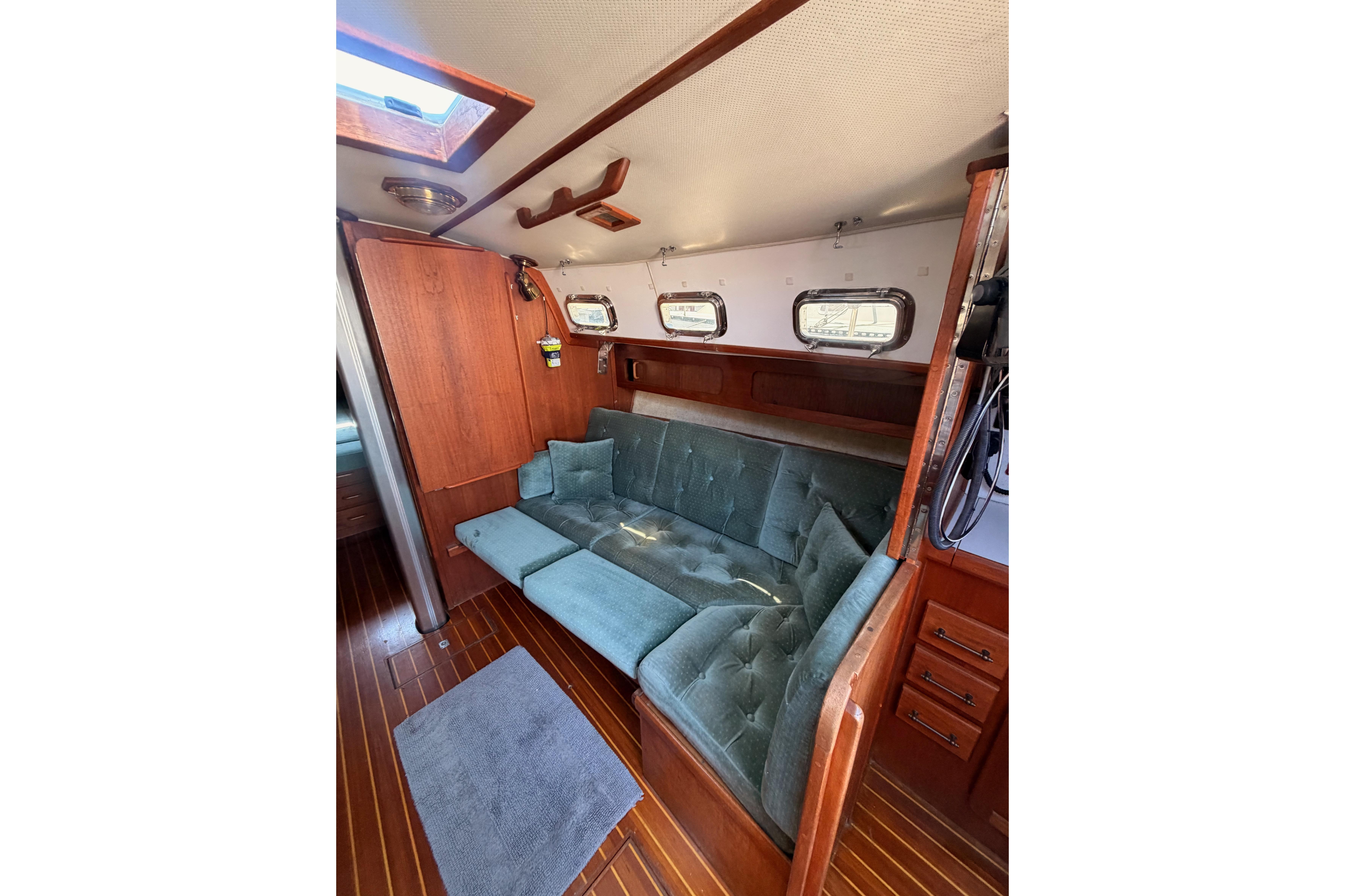 Interior of 1991 Caliber 33 sailboat with wooden paneling and blue cushioned seating.