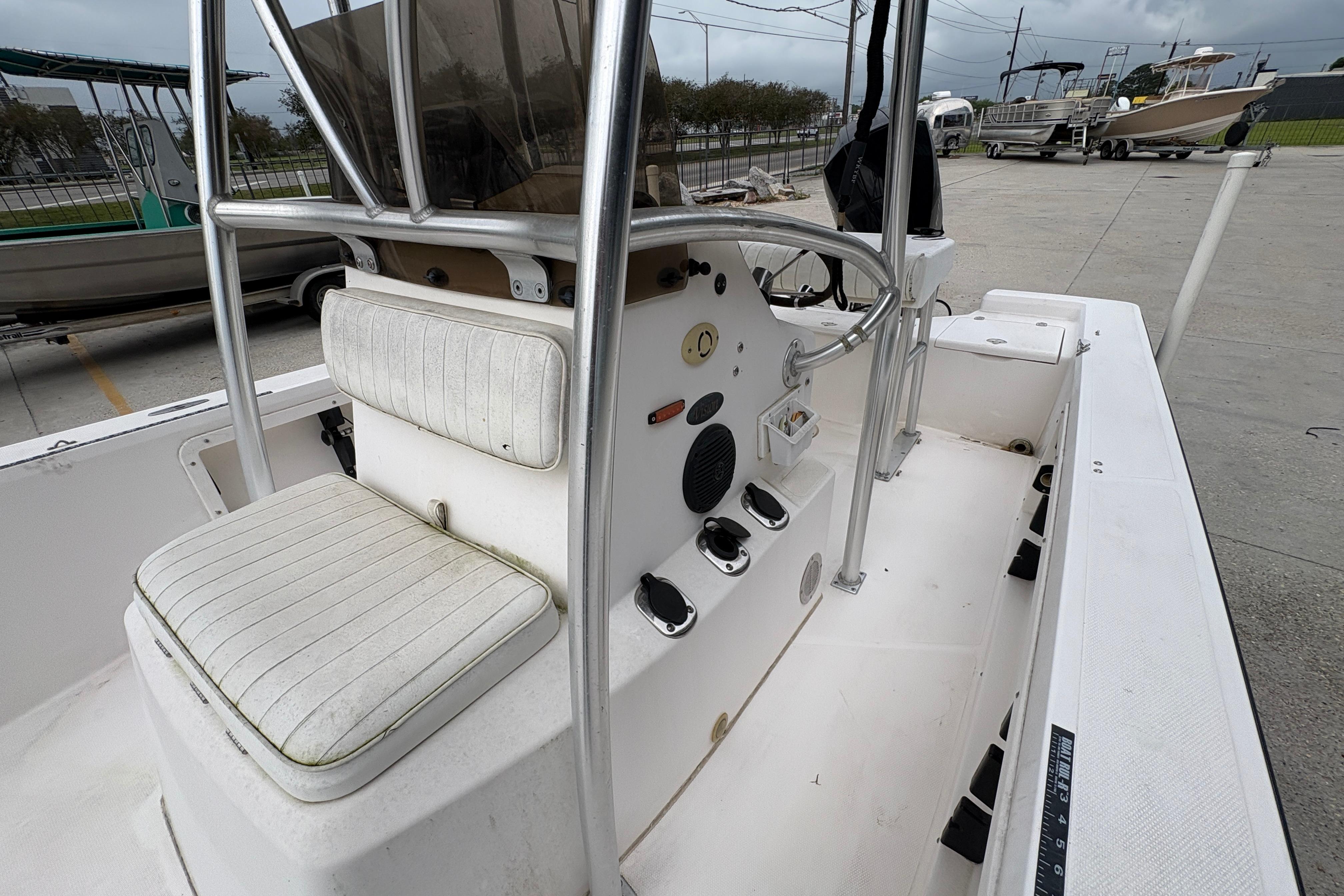 Kenner 21 VISION 2000 boat interior with steering console and seating, docked outdoors.
