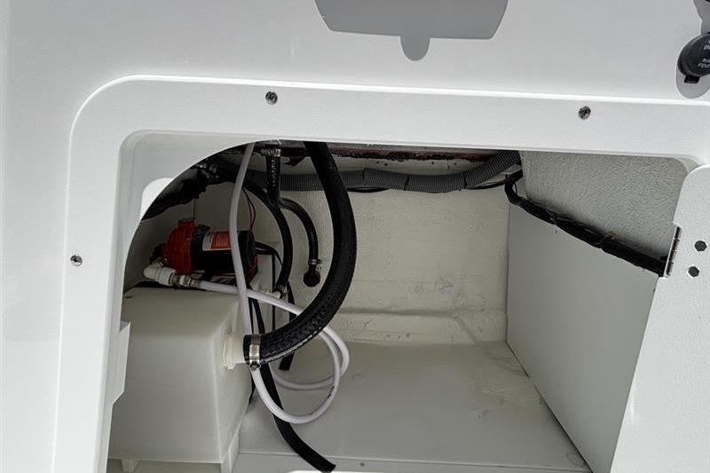 2026 Tahoe 2150 boat compartment with hoses and wiring, showcasing interior details.