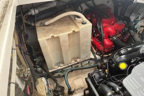 Engine compartment of a 2012 Bayliner 285 Cruiser, showcasing mechanical components and storage tank.