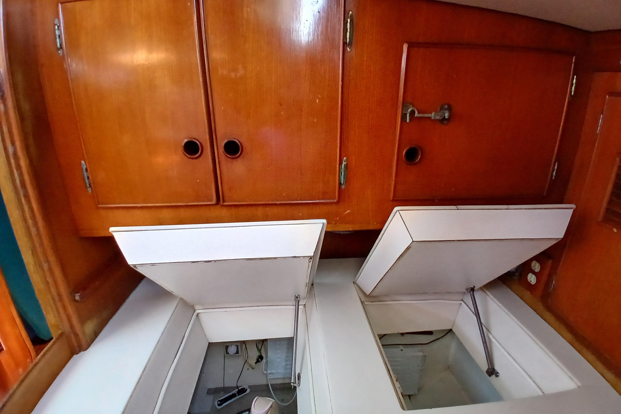 Wooden cabinets and open storage compartments in a 1981 SKYE 51 boat interior.
