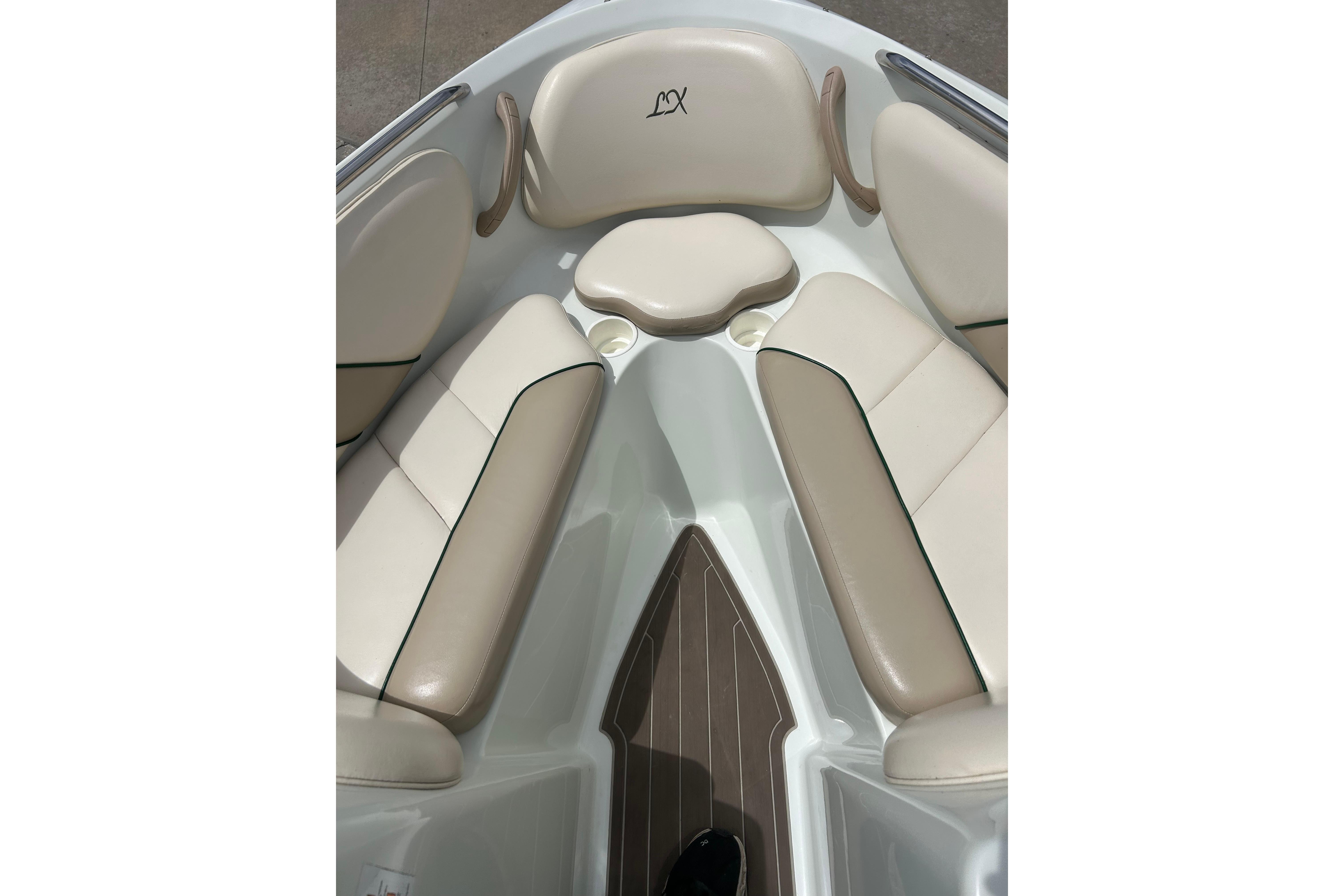 Interior view of a 2000 Starcraft 1810 boat with beige seating and cup holders.