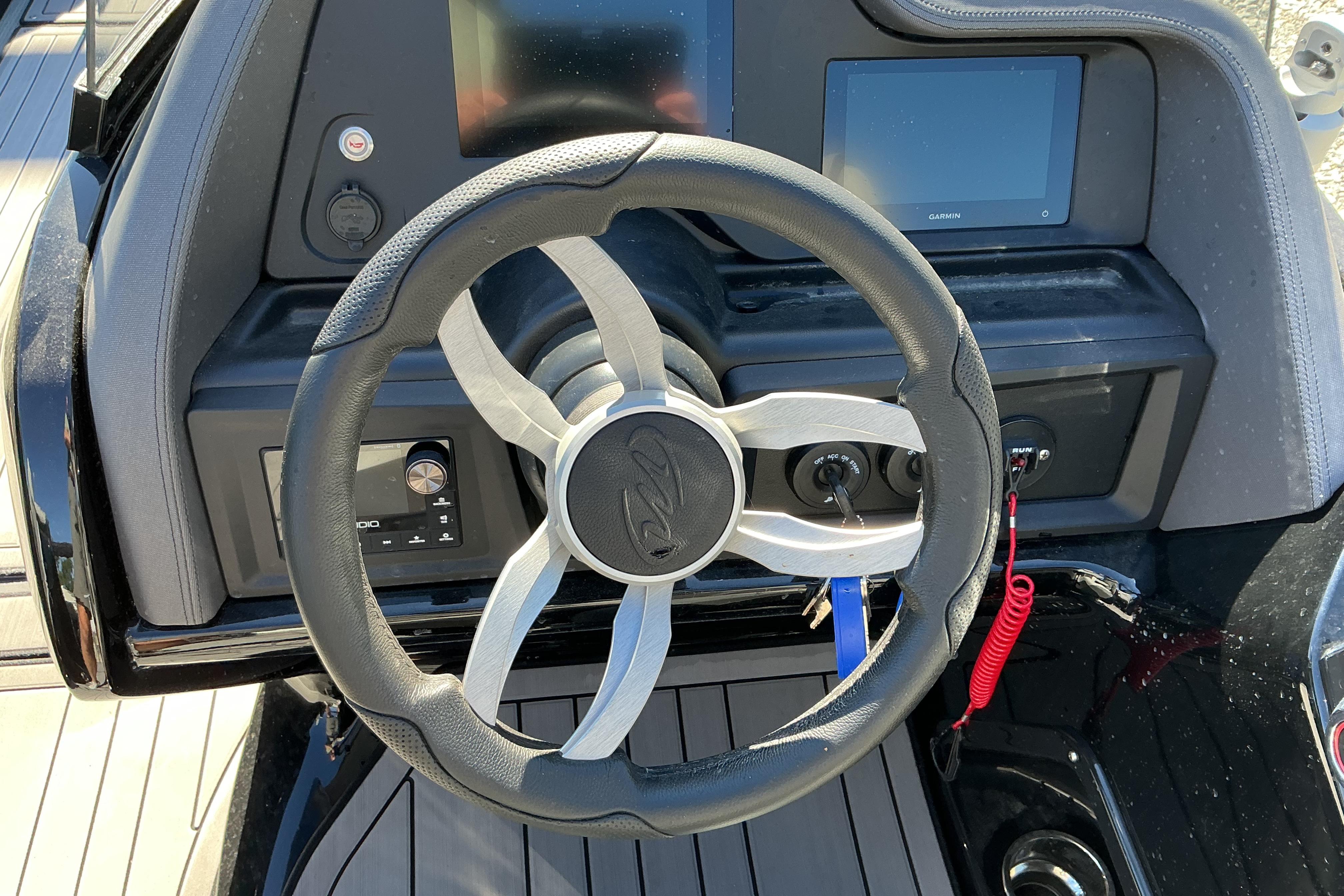 Steering wheel of 2024 Manitou 25 X-Plode XT SRS boat with dashboard controls.