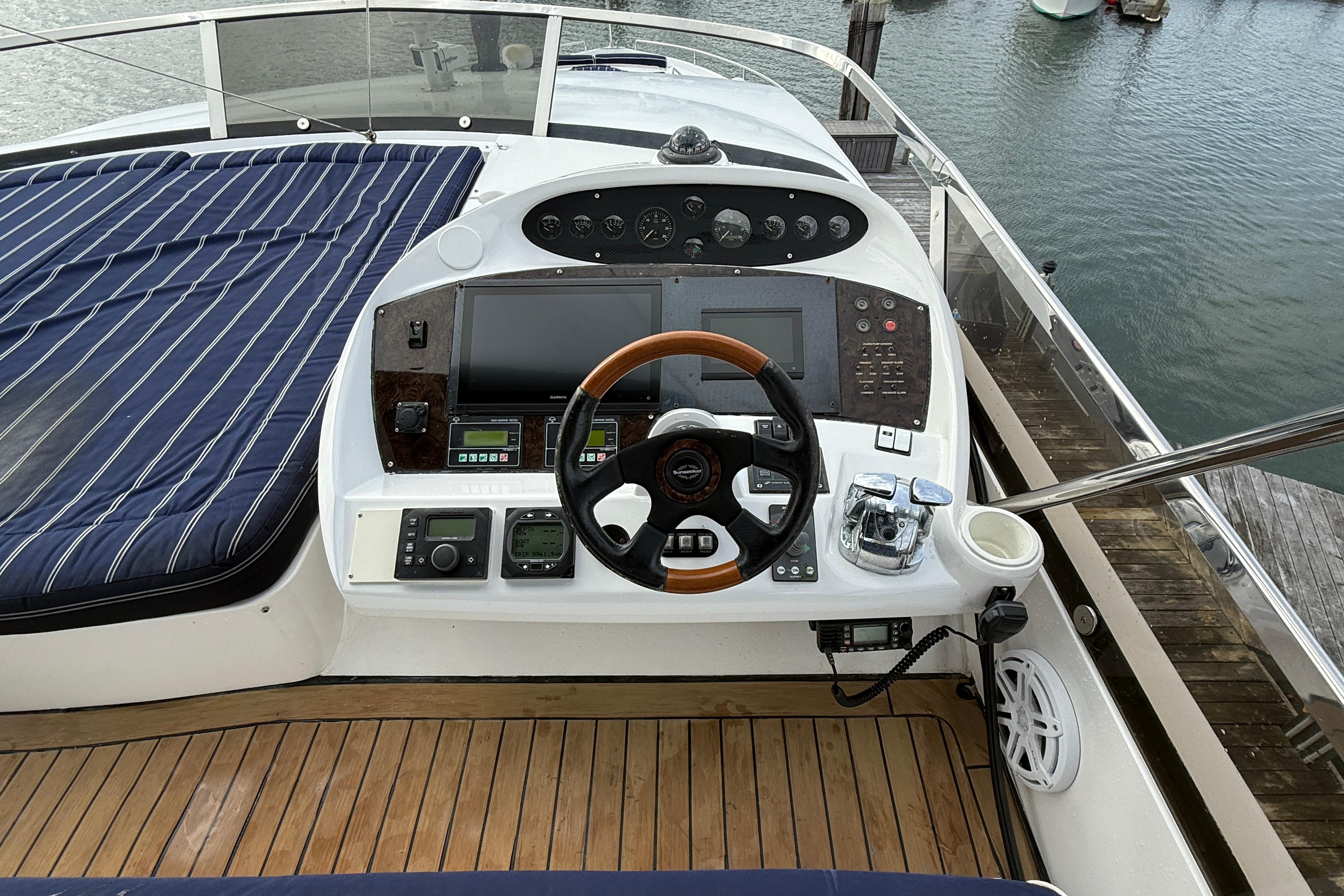Cockpit of 2005 Sunseeker 75 Yacht with wooden steering wheel and navigation controls.