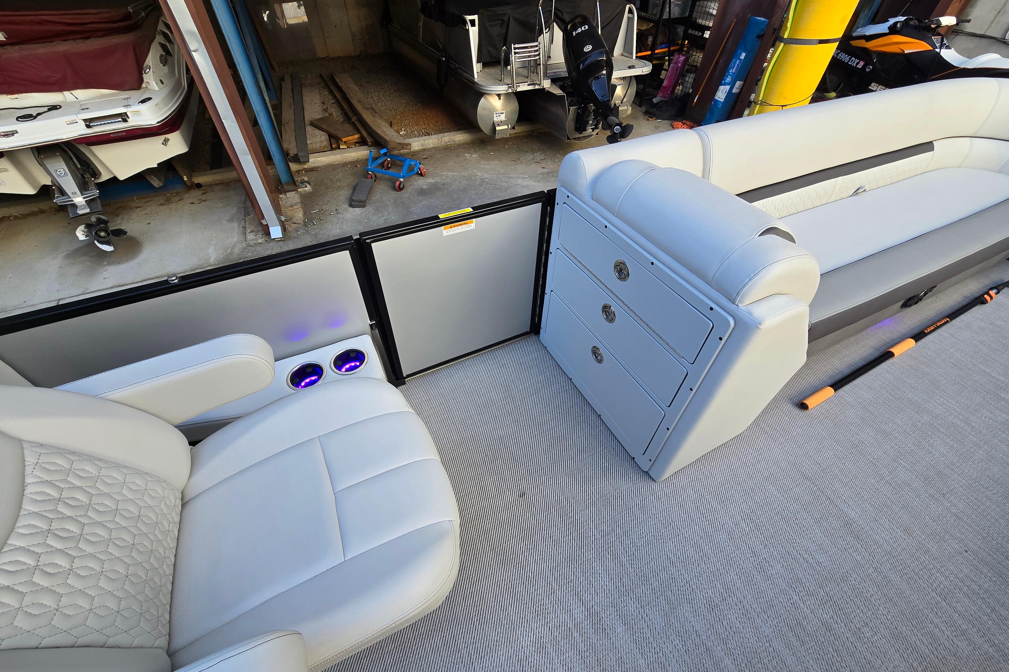 Interior of 2024 Godfrey Sweetwater 2486 SB pontoon boat with plush seating and storage.