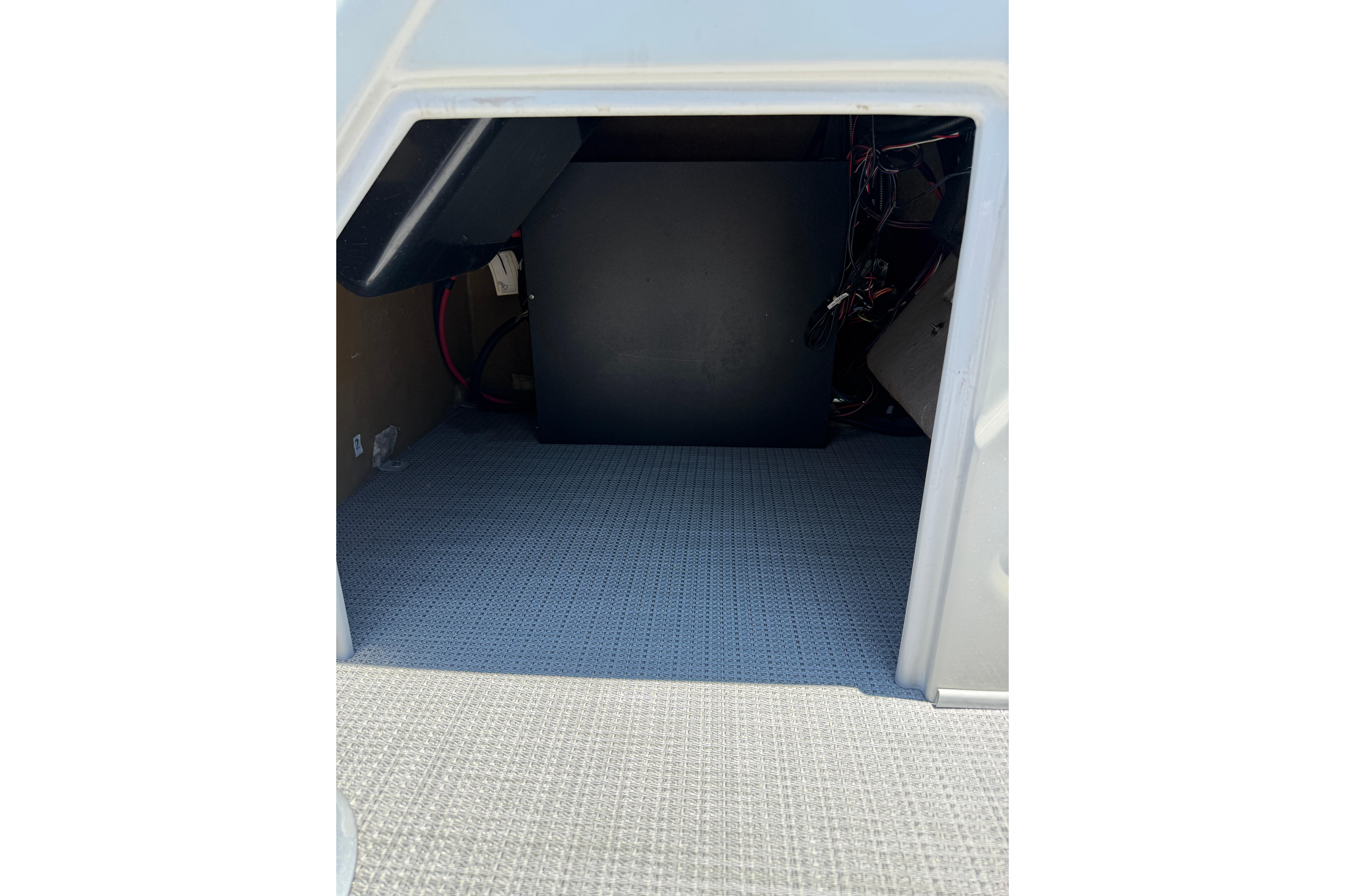 2024 Regency R250DL3 interior storage compartment with carpeted flooring and wiring.