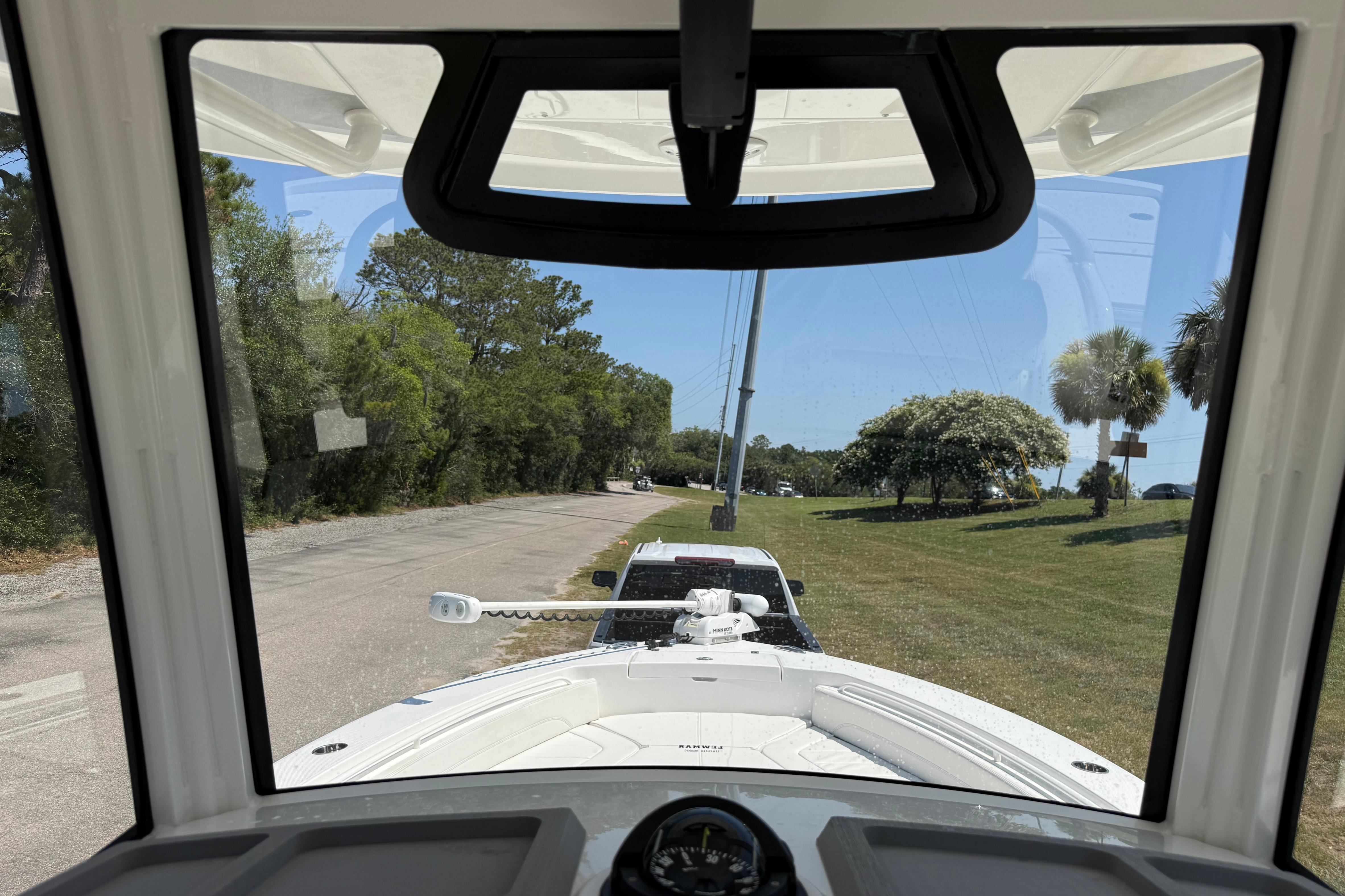 2023 Regulator 26XO boat view from cockpit, parked on a scenic road.