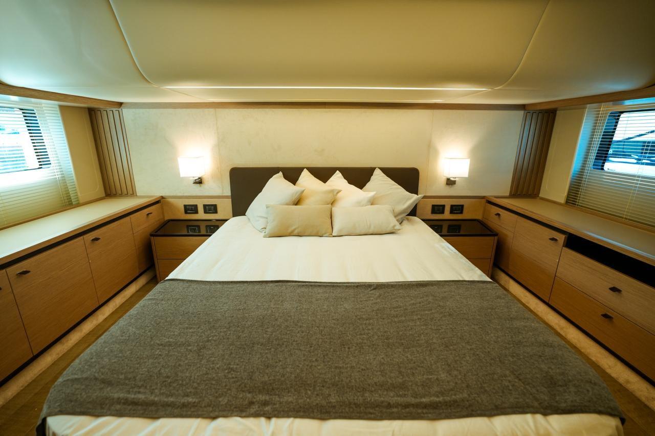 Luxurious bedroom interior of 2024 Absolute NAVETTA 52 yacht with modern design and cozy ambiance.
