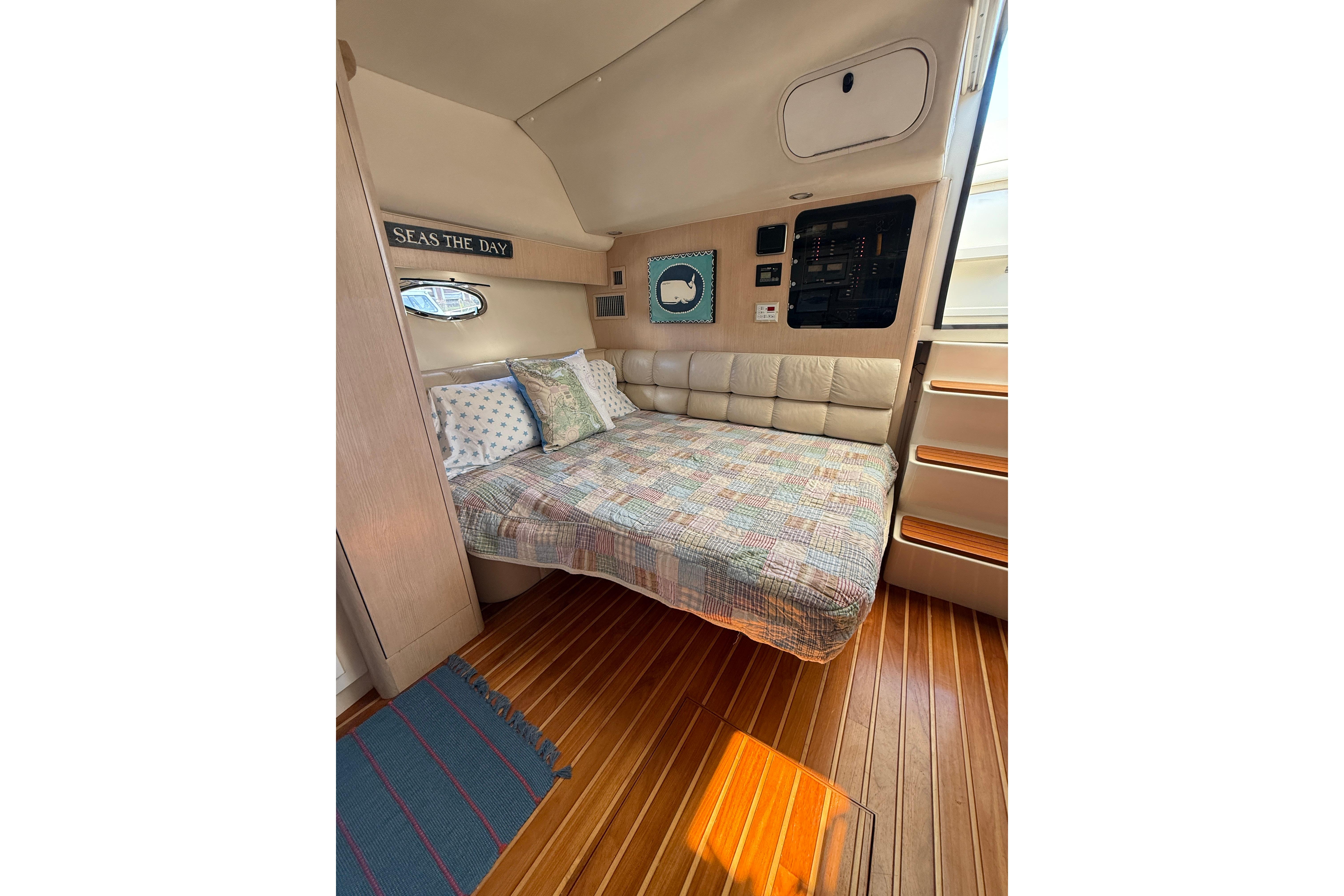 Cozy cabin interior of 1996 Tiara Yachts 3500 Express with bed and nautical decor.