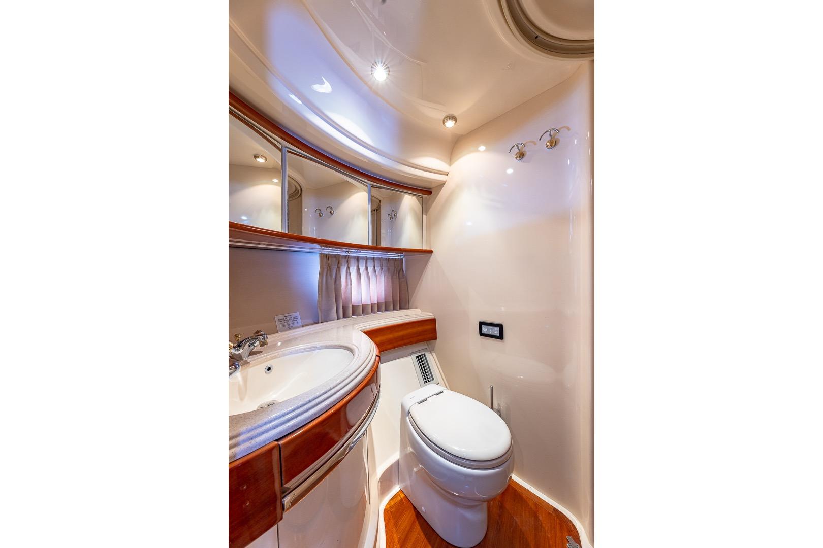 Luxurious bathroom in 2003 Azimut Fly 68 yacht with elegant fixtures and wood accents.