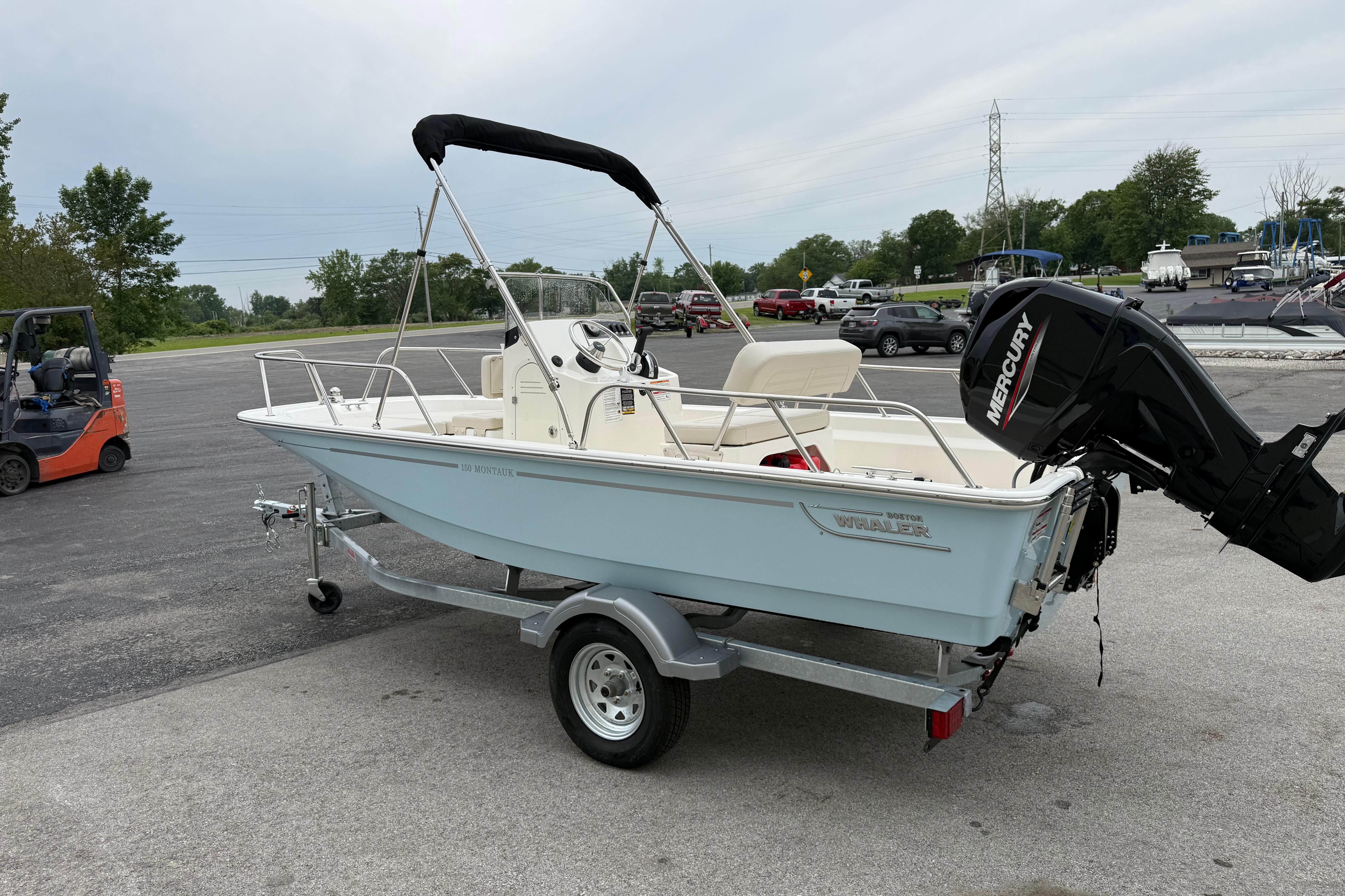 2026 Boston Whaler 150 Montauk boat on trailer, featuring Mercury outboard motor.
