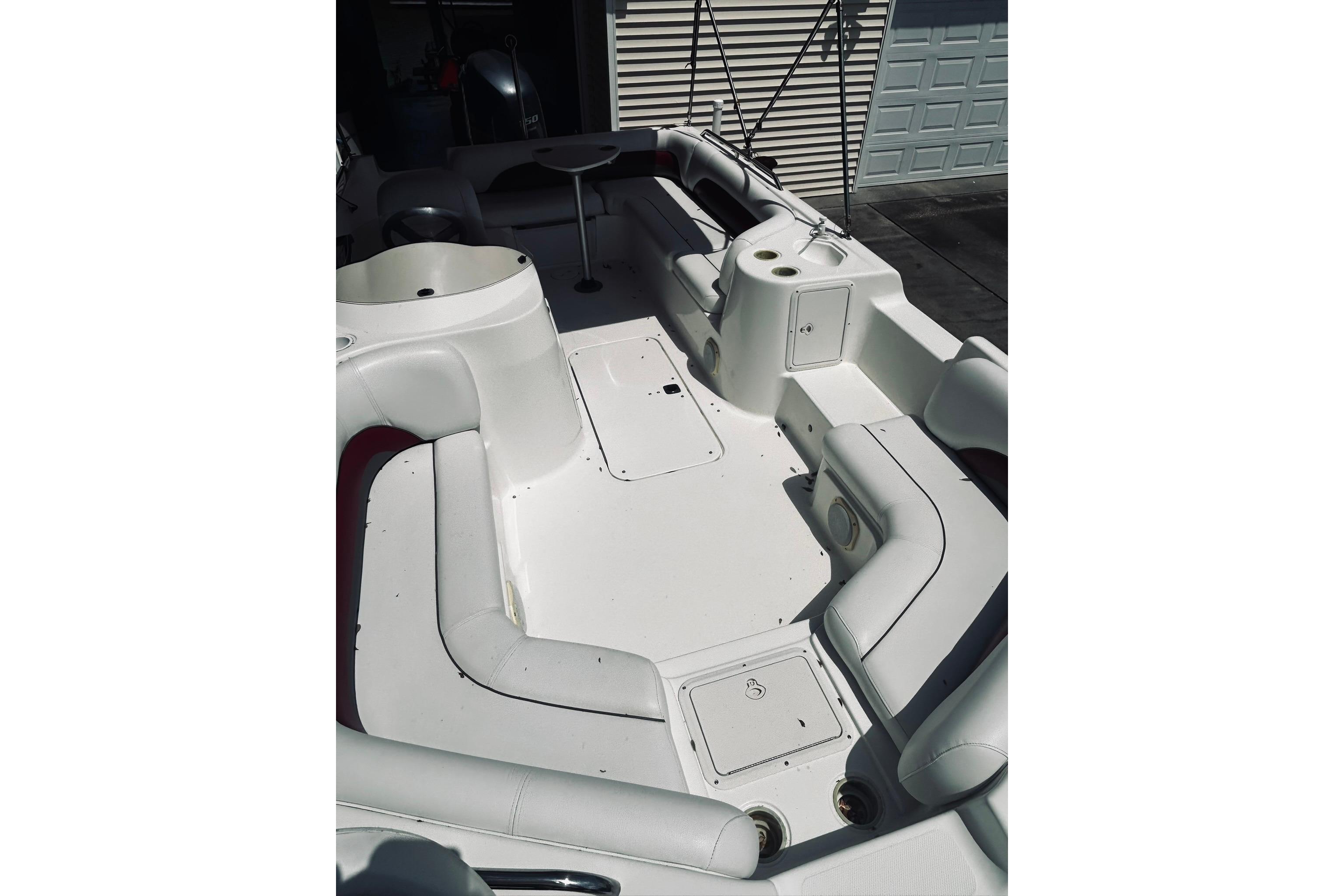 2013 Hurricane SunDeck Sport 201 OB boat interior with white seating and storage compartments.