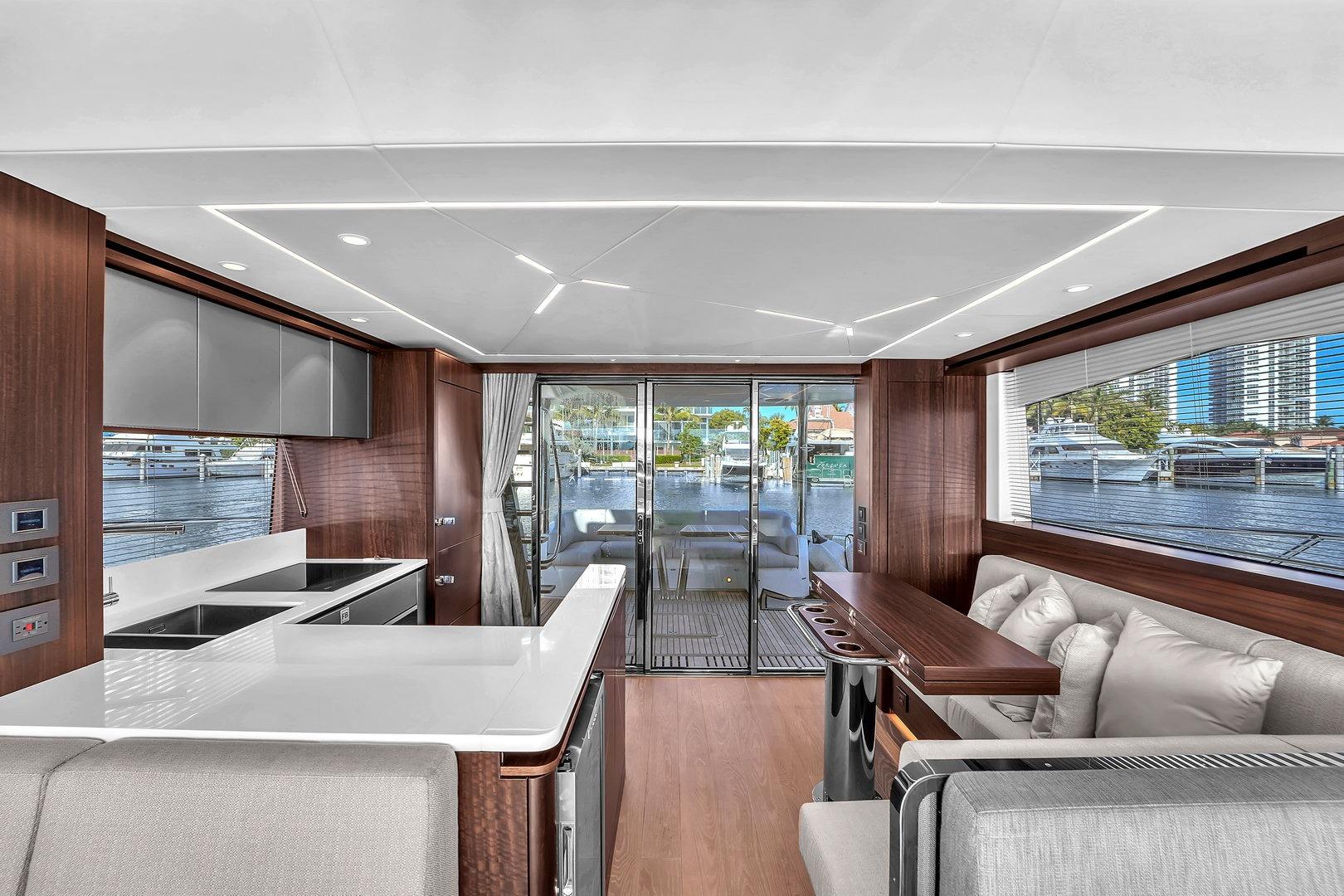 Luxurious interior of 2023 Sunseeker Manhattan 68 yacht with modern kitchen and seating area.