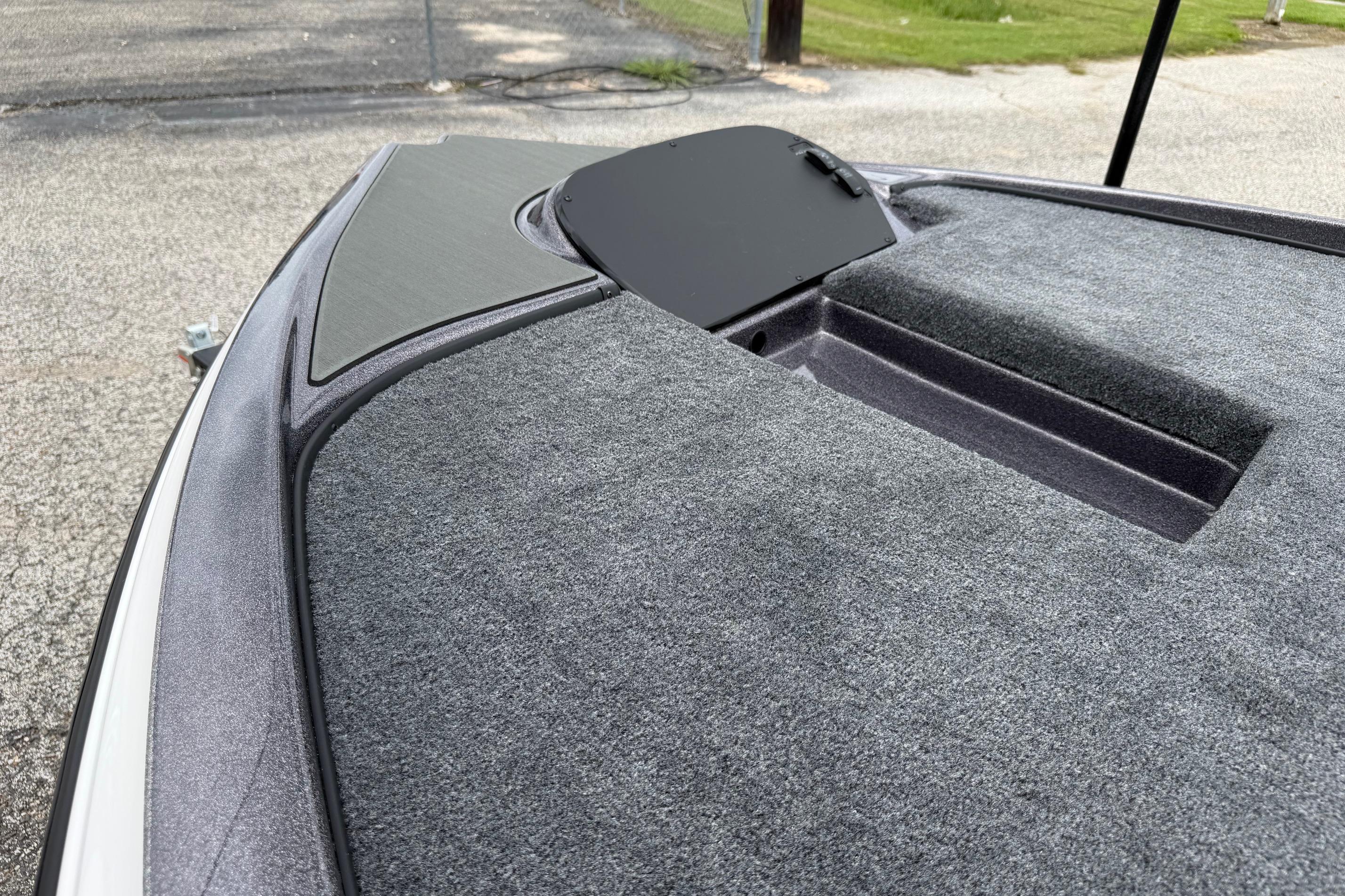 2027 Falcon Boats F215 deck with carpeted surface and storage hatch.