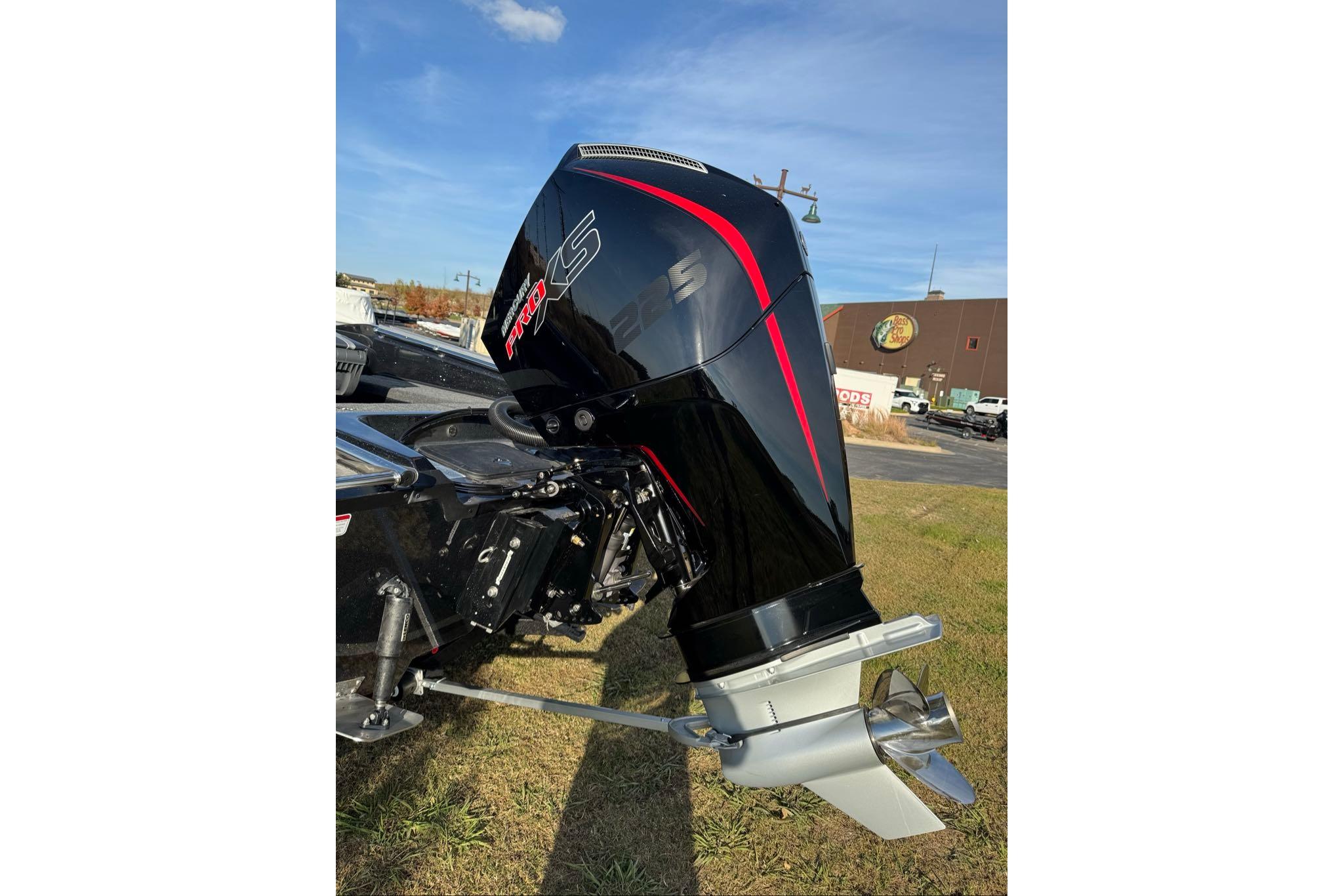 2026 Nitro ZV20 Pro outboard motor, sleek black design with red accents, on grassy area.