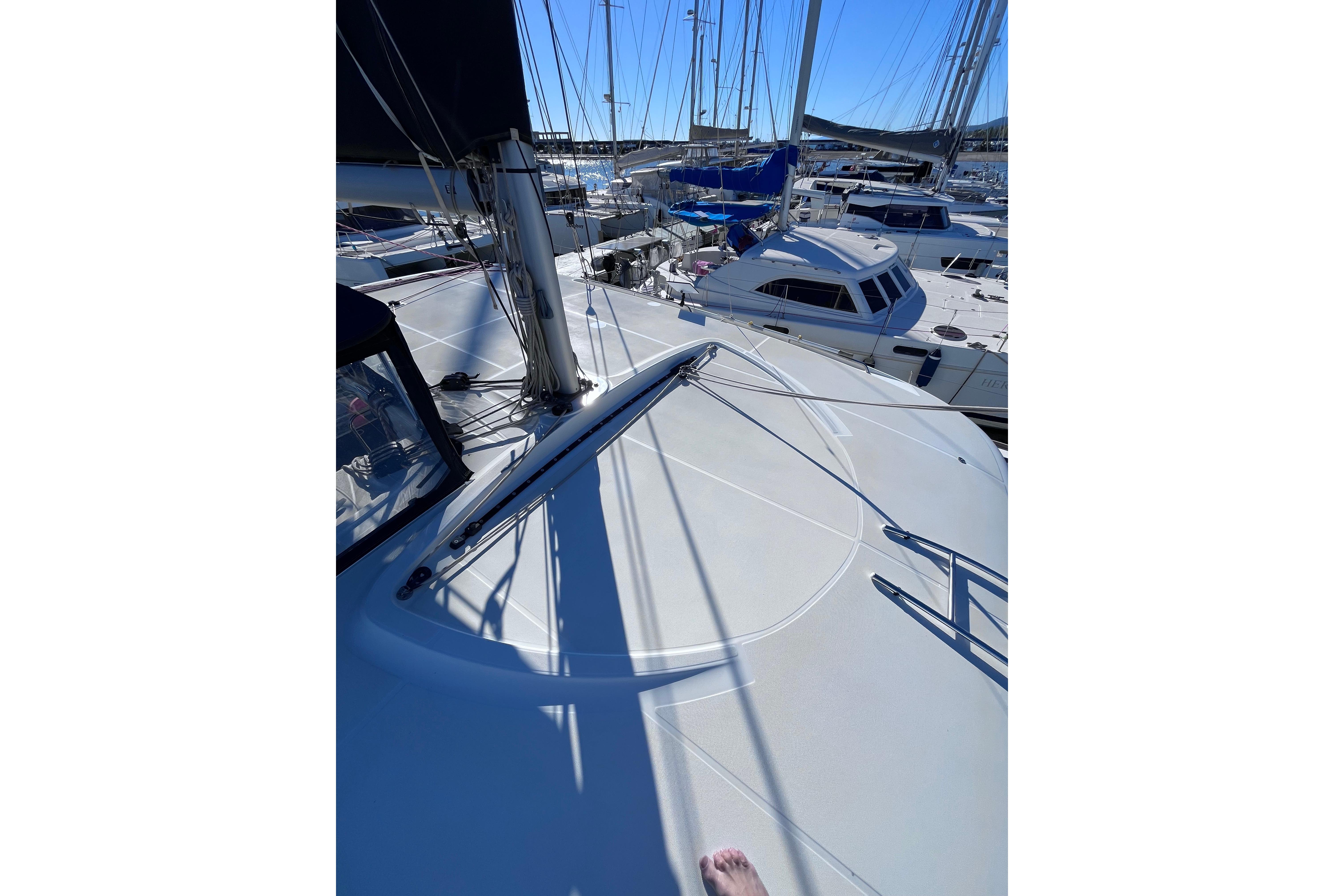 2023 Lagoon 40 catamaran deck view in a marina, showcasing sleek design and rigging.