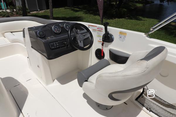 2018 Bayliner 210 DB boat cockpit with steering wheel and comfortable seating.