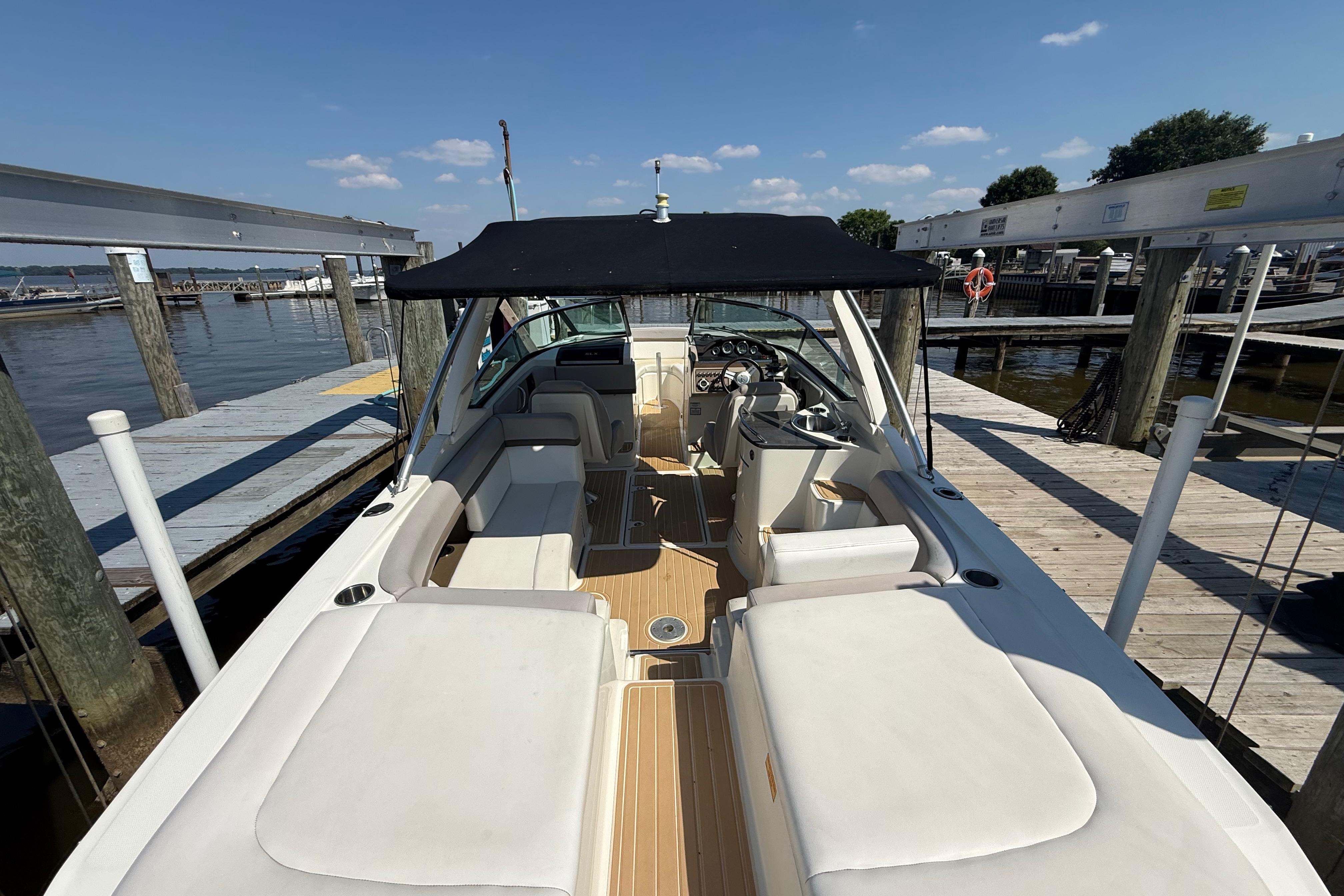 2011 Sea Ray 270 SLX boat docked, featuring spacious seating and a black canopy.